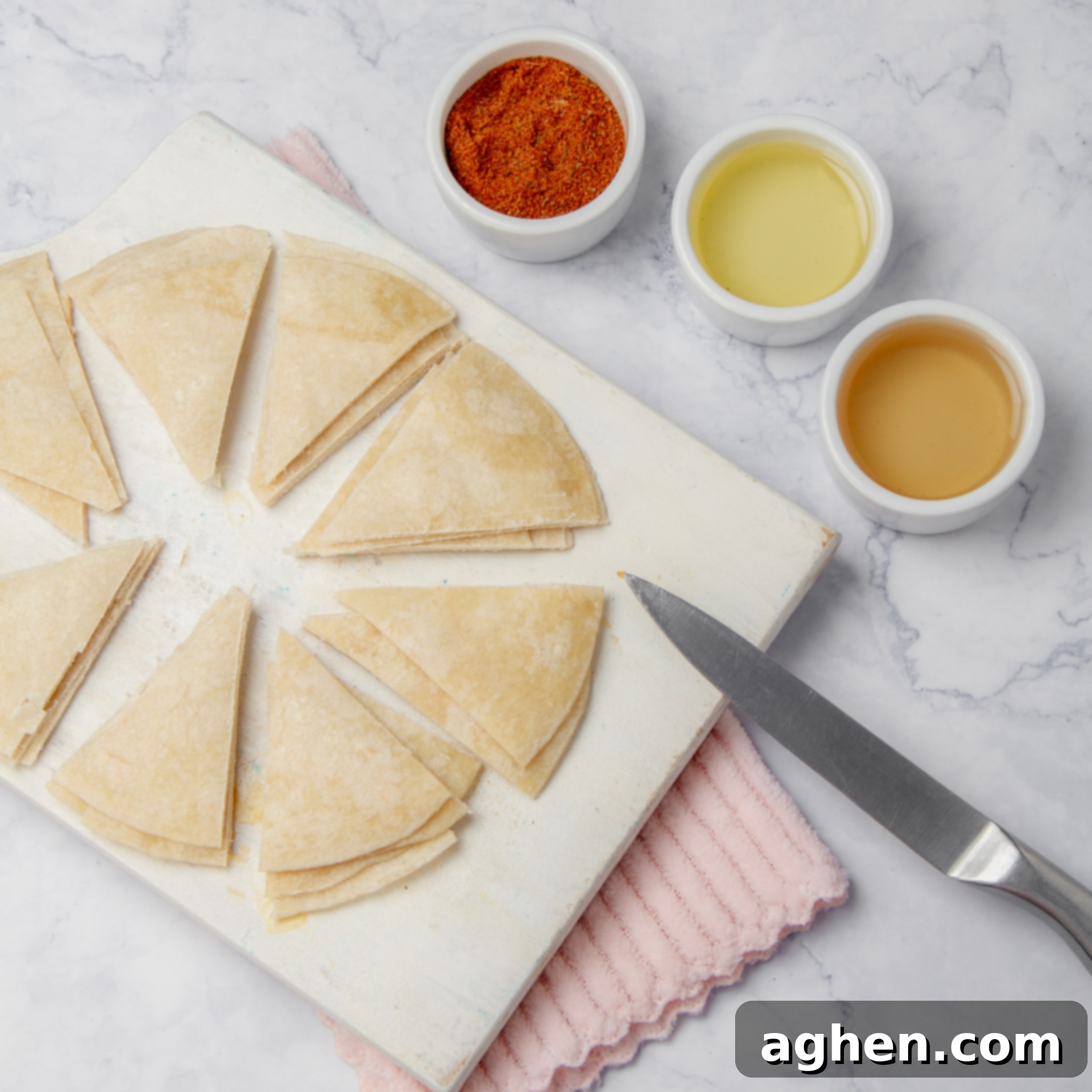 Weight Watchers Diyeti İçin Harika Ev Yapımı Tostitos Atıştırmalığı 4 A stack of flour tortillas cut into uniform triangles on a cutting board, ready for seasoning.