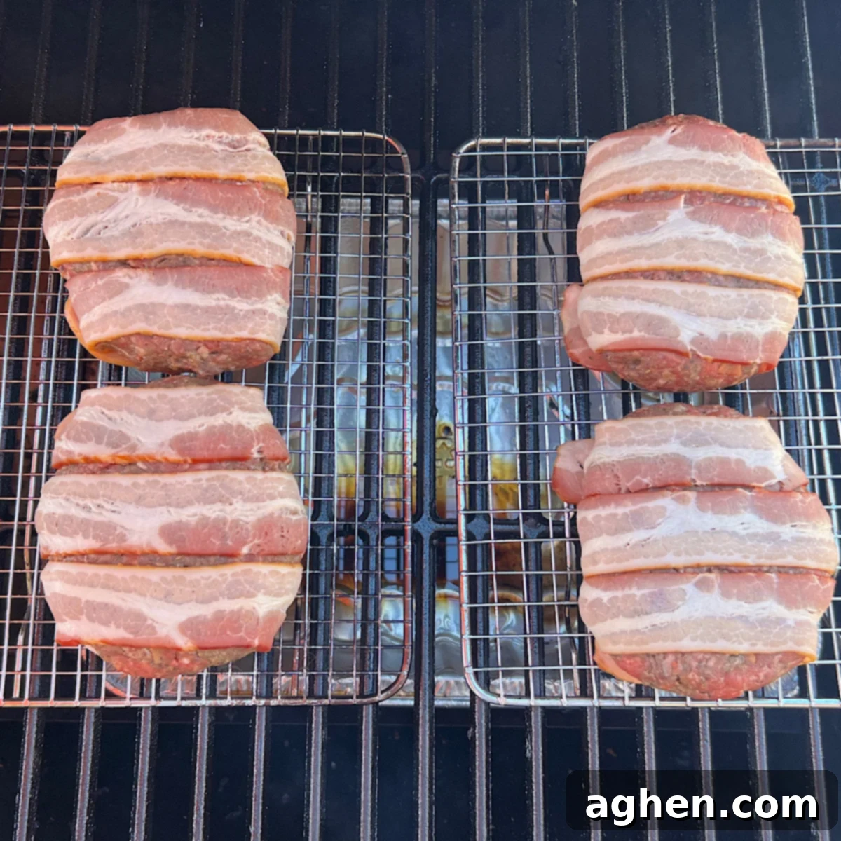 raw bacon burgers resting on a grill grate within the smoker, ready to cook