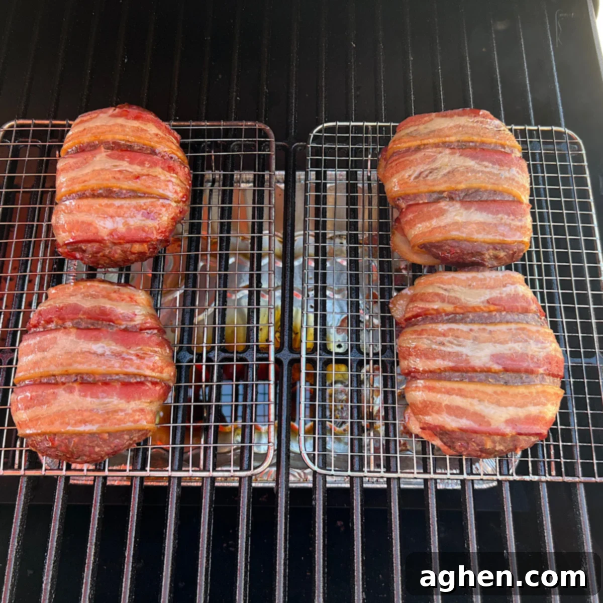 smoking bacon burgers on a gill grate, with smoke visible