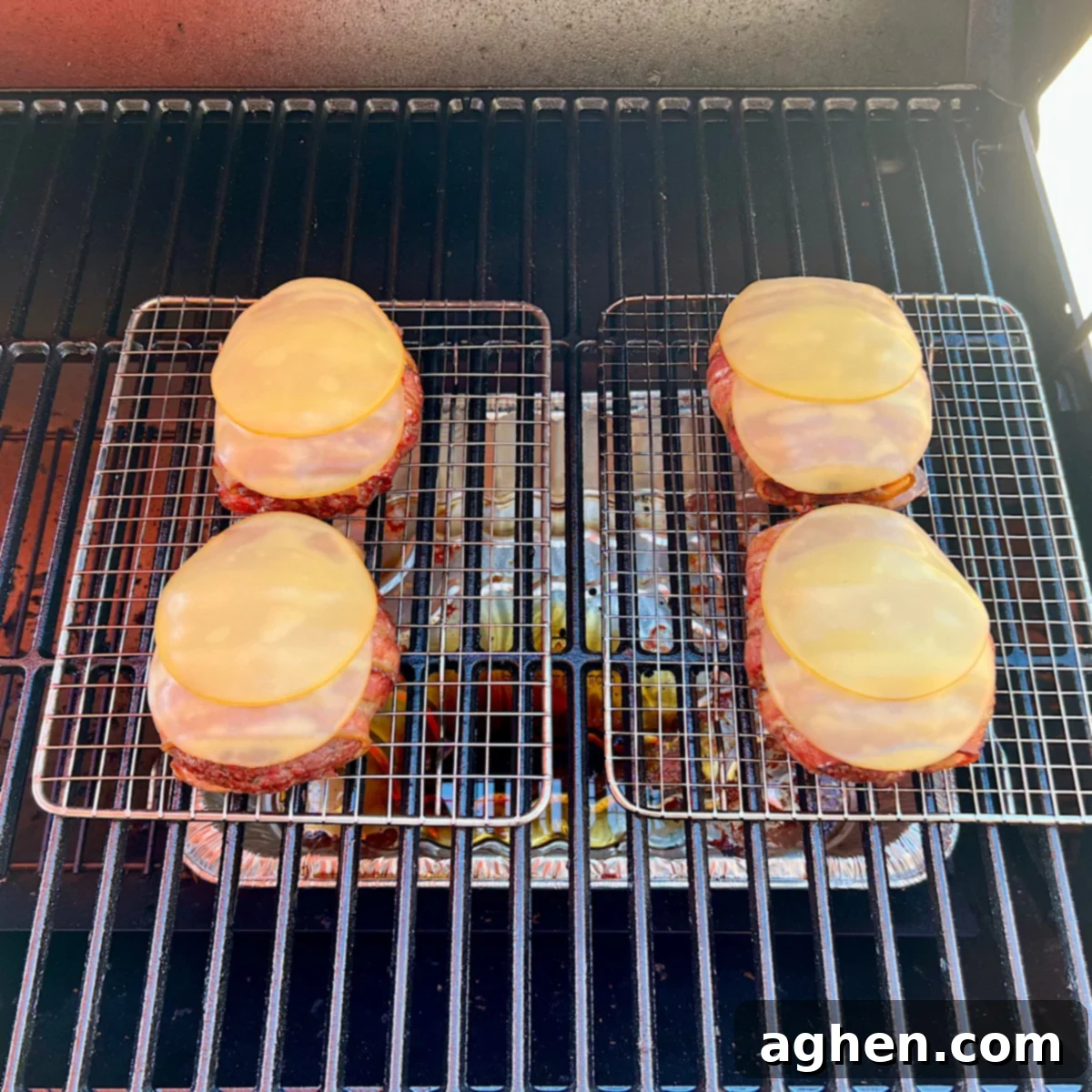 smoking bacon burgers with melted gouda cheese on top
