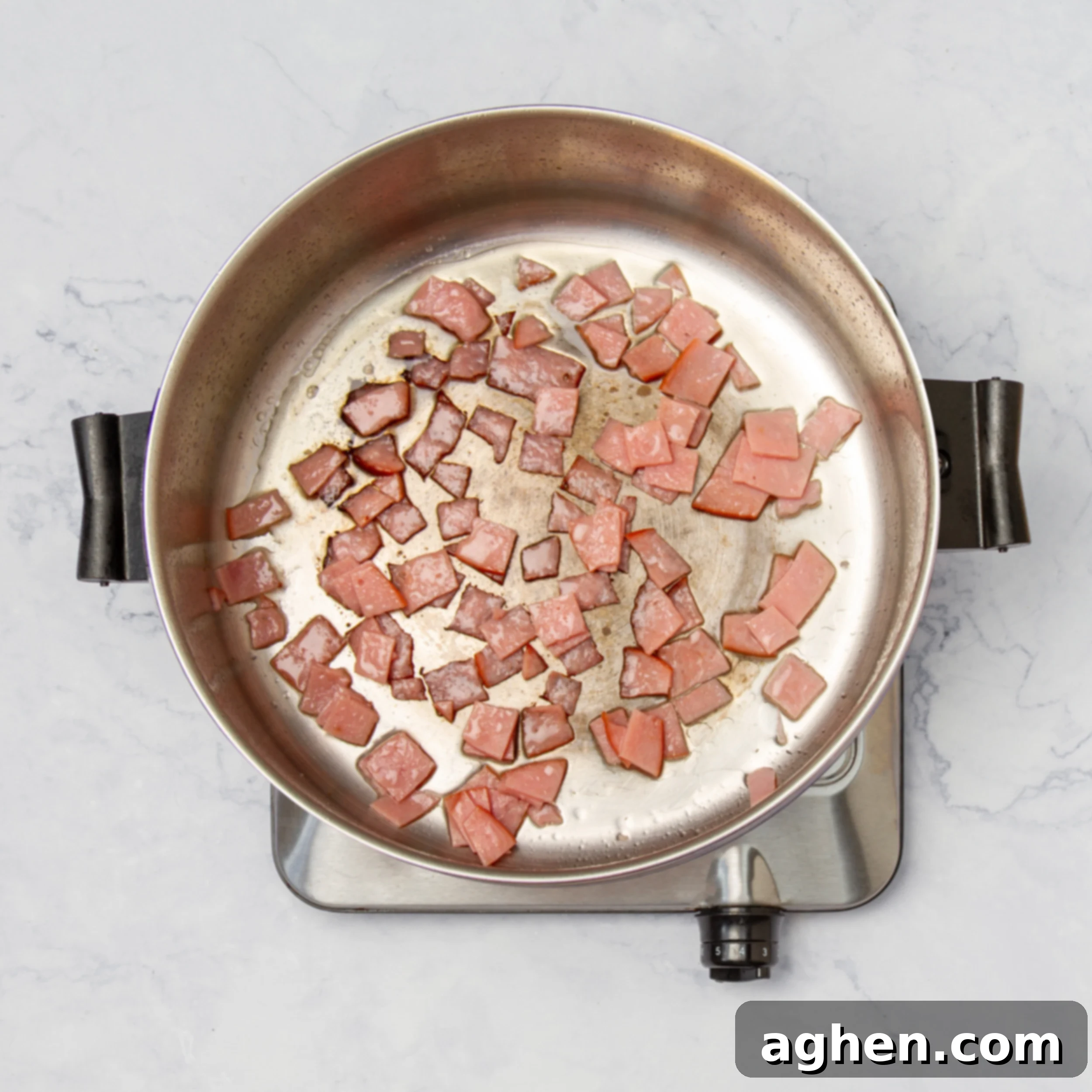 Diced ham crisping in a hot pan. 