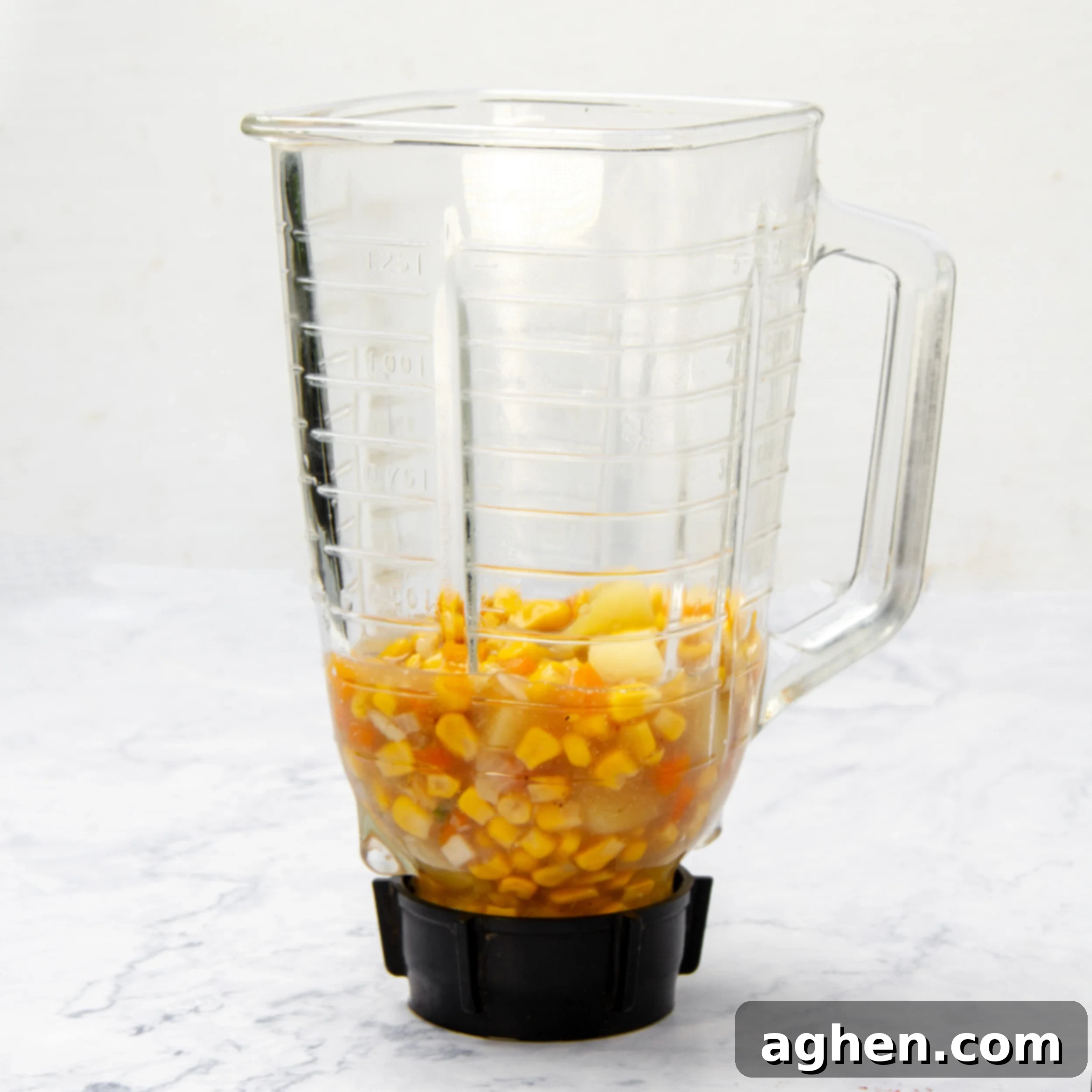 Cooked soup ingredients added to a blender. 