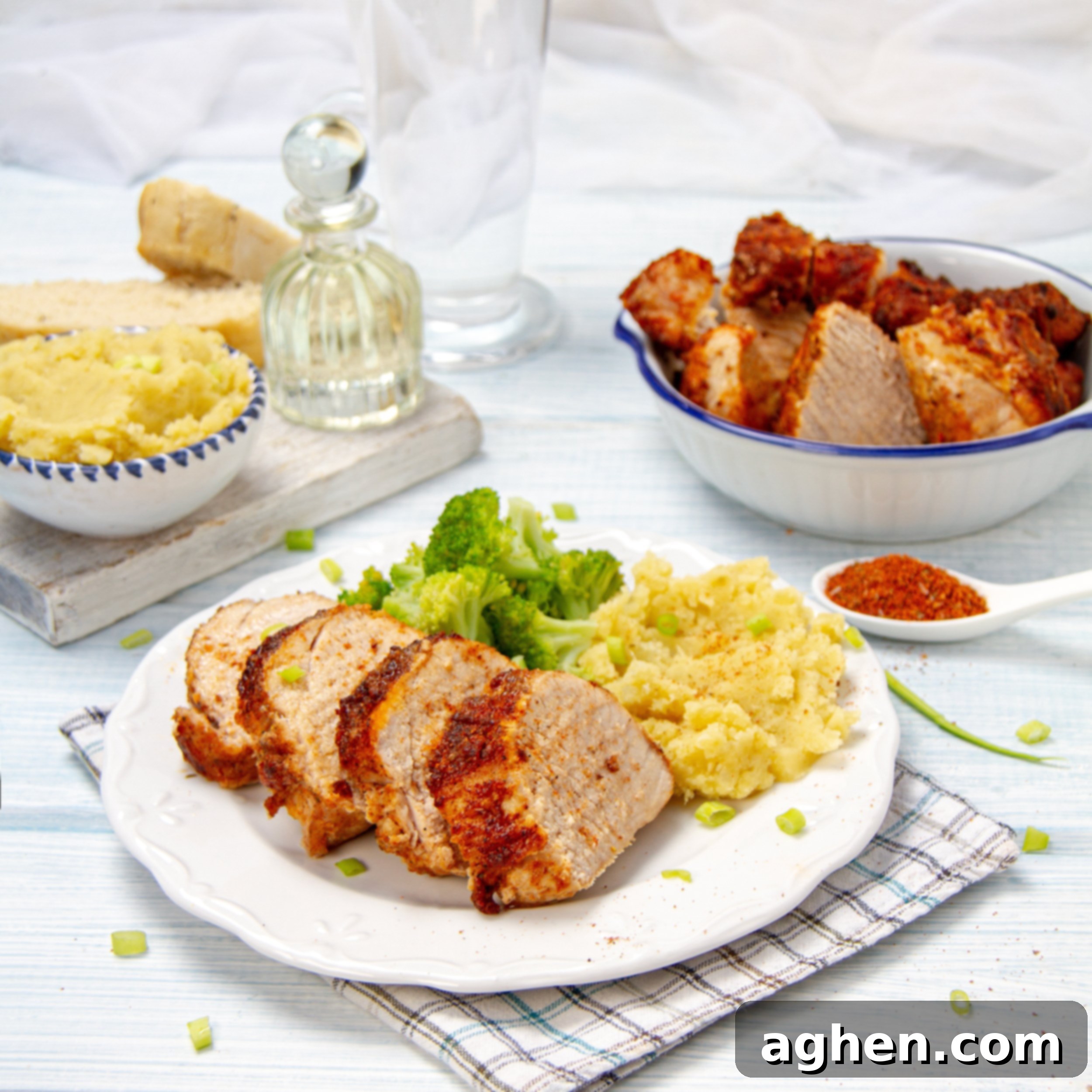 Juicy marinated air fryer pork tenderloin sliced on a plate with rice and broccoli.