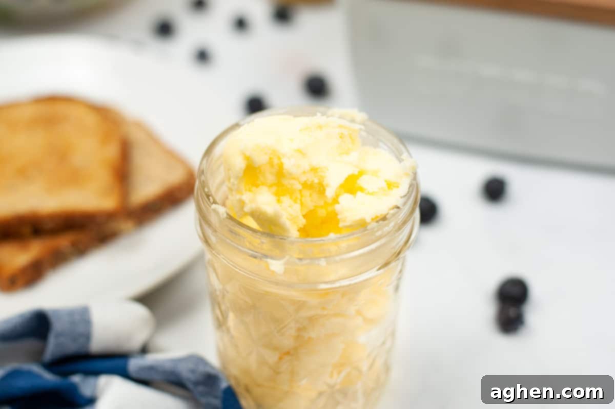 From Cream to Gold 3 Jar of butter with toast and berries in background, illustrating a delicious use for homemade butter.