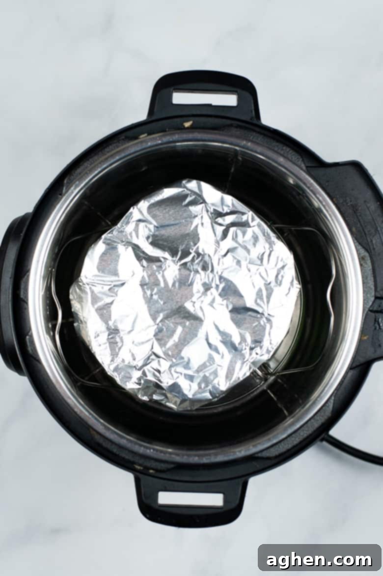 Aluminum foil covered silicone egg bite mold placed inside the Instant Pot on a trivet, ready for pressure cooking