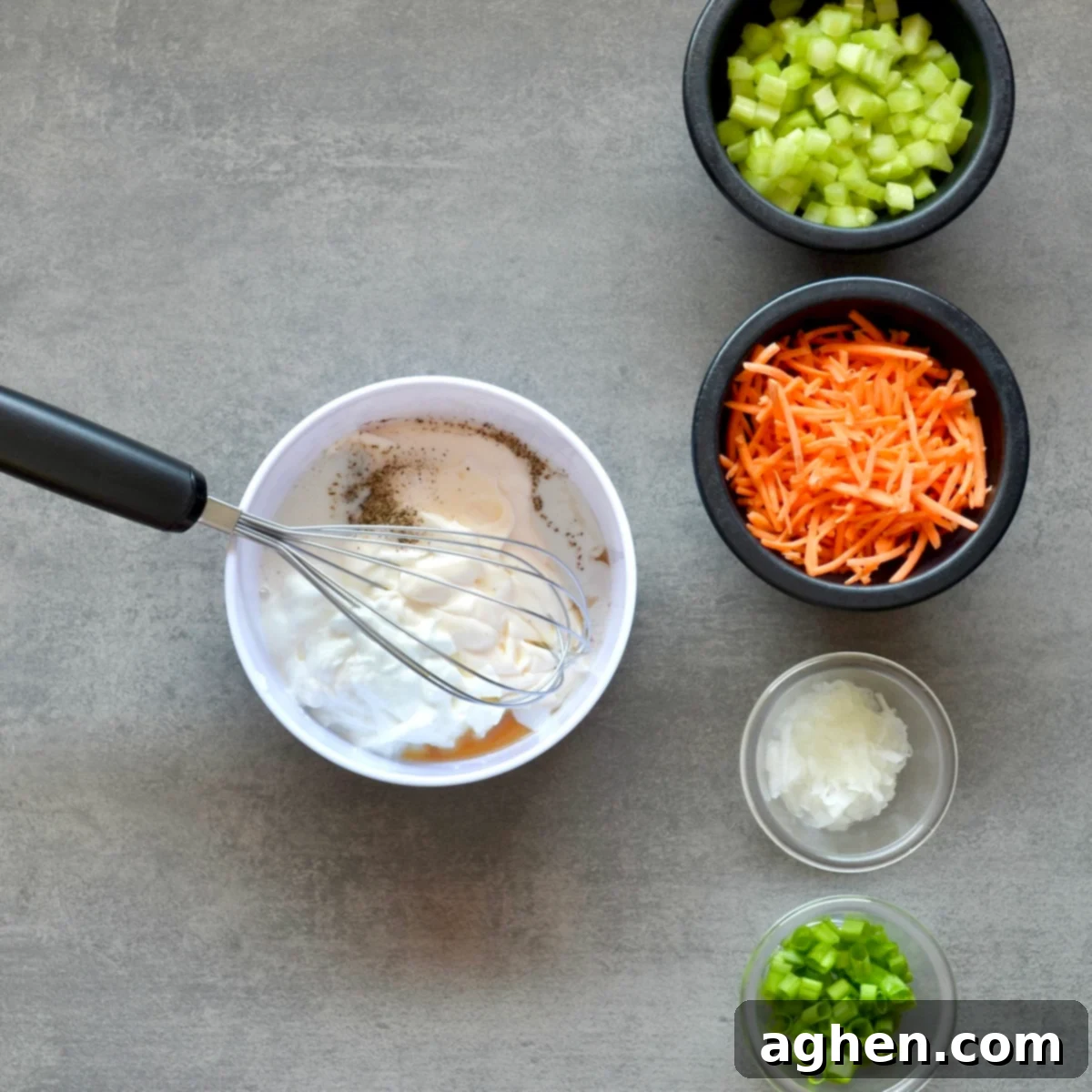 A bowl of creamy dressing being whisked with a spoon, highlighting the smooth texture.