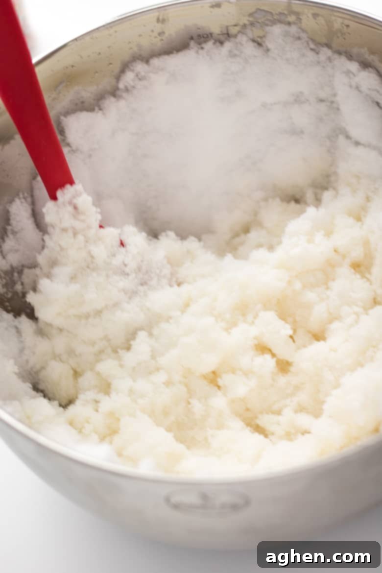 homemade ice cream in a large silver bowl with red spatula