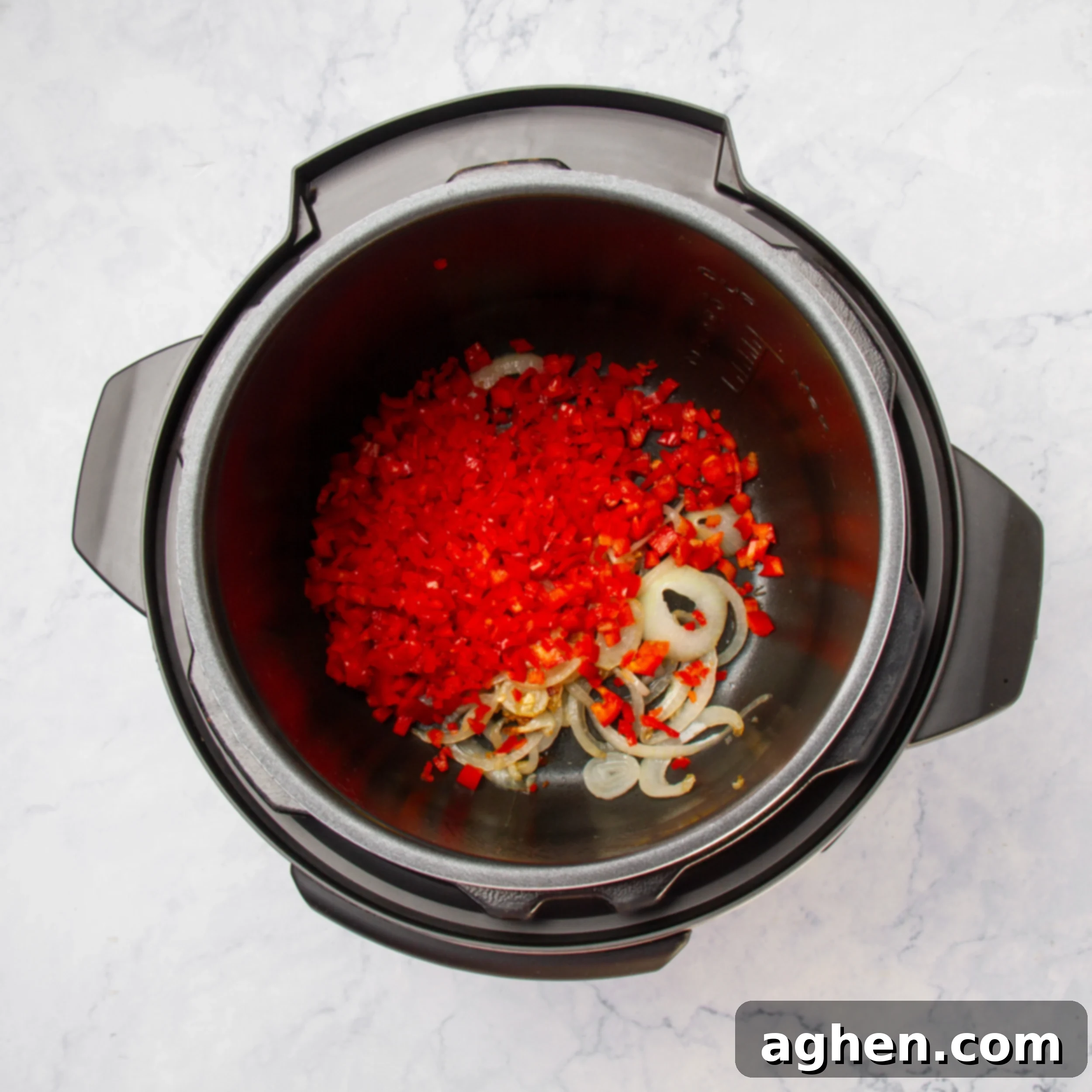Aromatics and vegetable ingredients sauteing in the instant pot. 