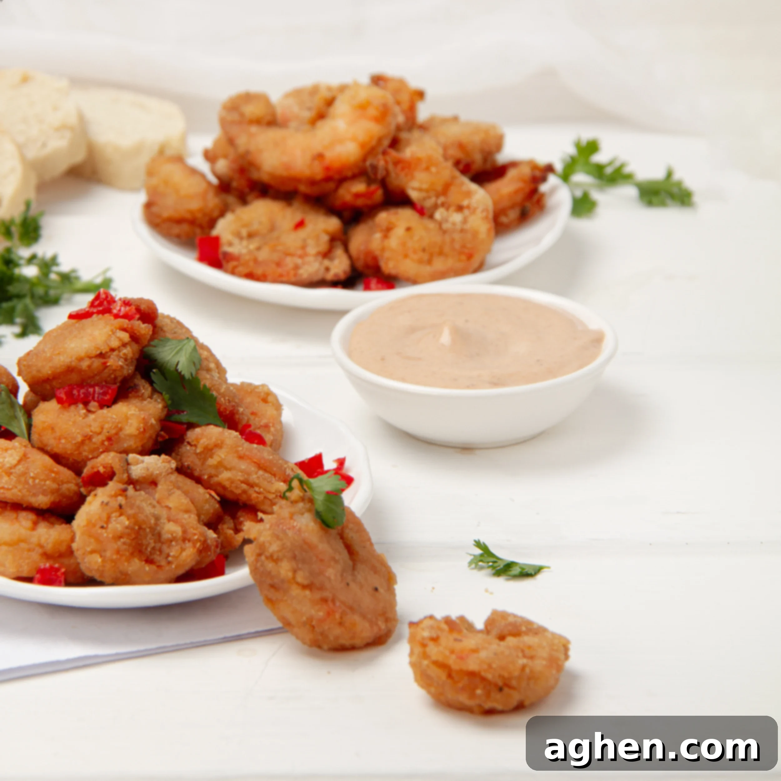 Perfectly Crispy Air Fryer Shrimp 2 Crispy battered Air Fryer Shrimp on a plate with a dish of dipping sauce.