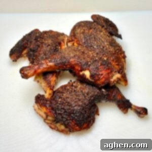 A beautifully grilled spatchcock chicken, golden brown and expertly carved into quarters, presented on a wooden board ready to serve.