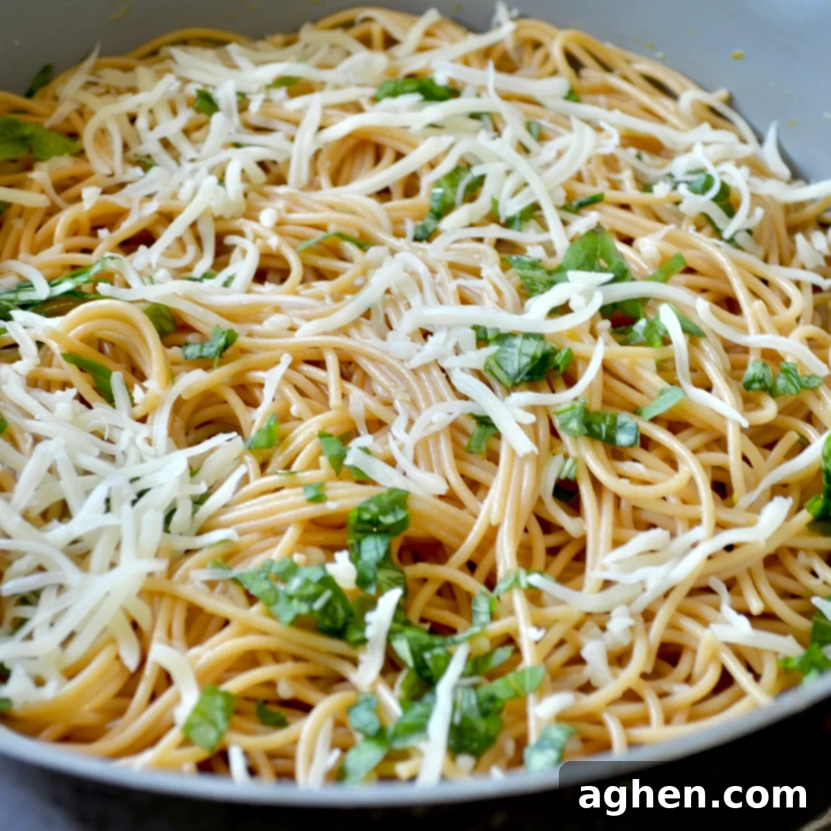 Adding cheese and basil to spaghetti