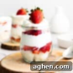 strawberry, angel food cake, and whipped cream trifle in small glass jar