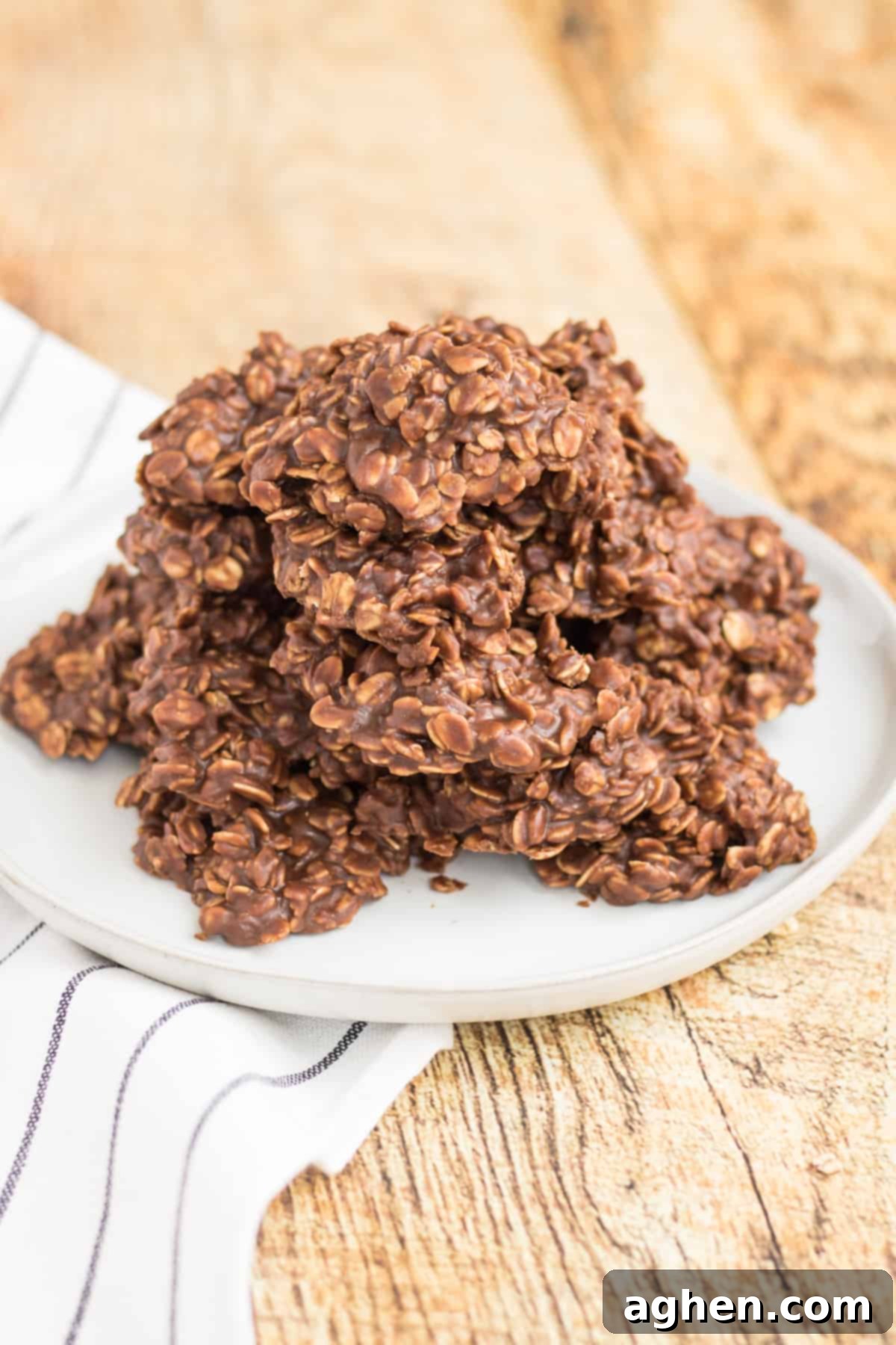 Old-fashioned no-bake chocolate peanut butter oatmeal cookies served on a white plate on a wooden table.