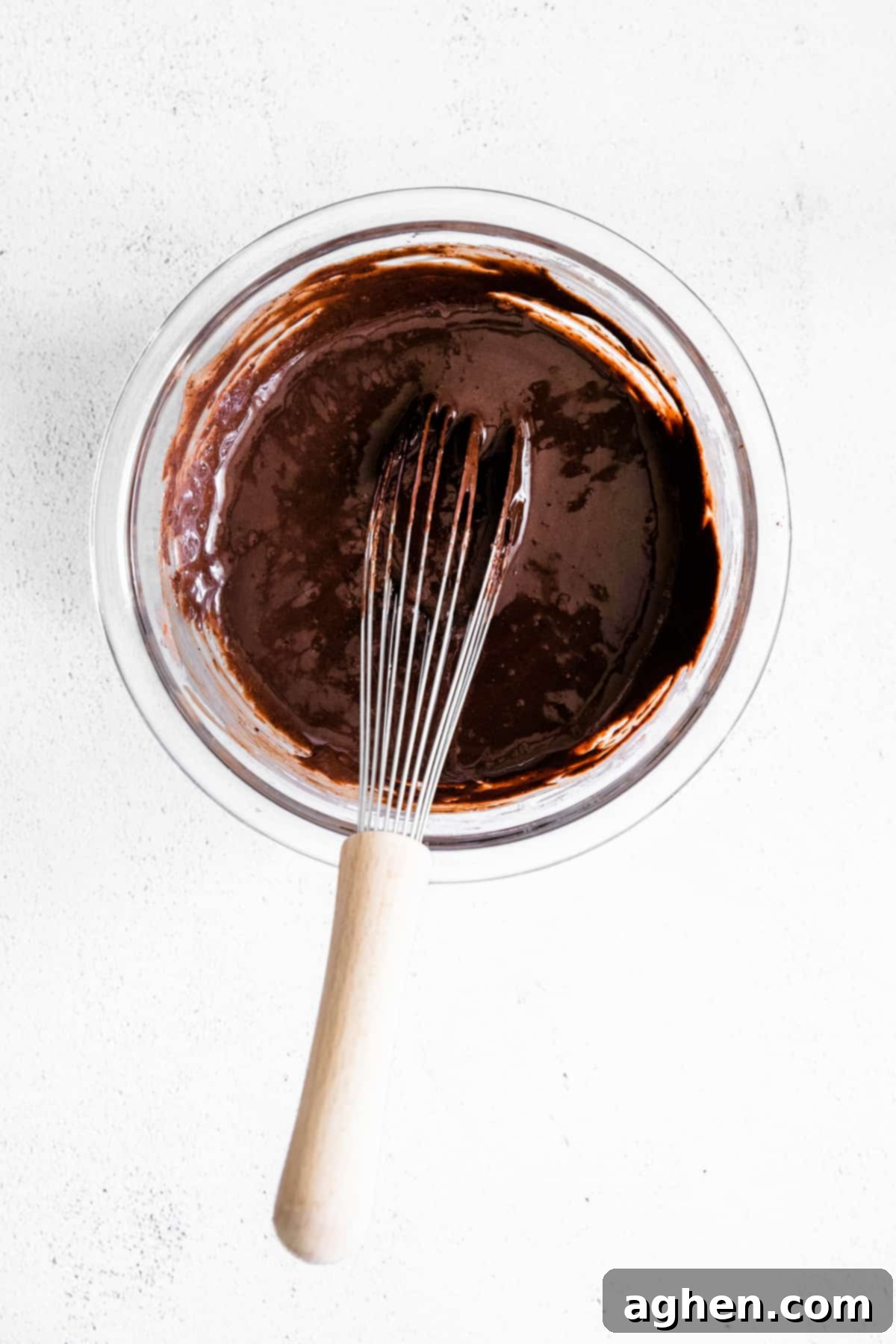 melted chocolate in glass bowl with wire whisk