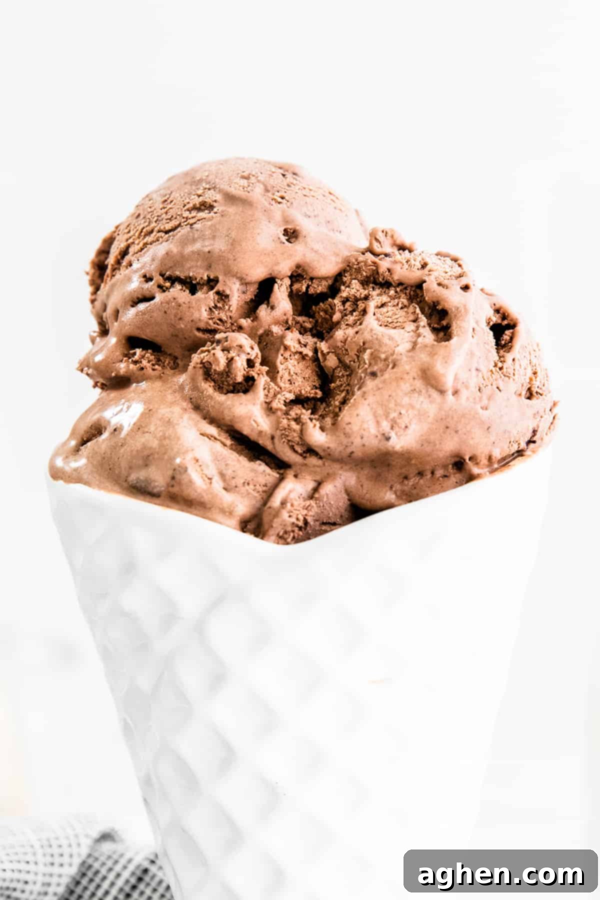 Rich and creamy no-churn chocolate ice cream in white bowl shaped like an ice cream cone