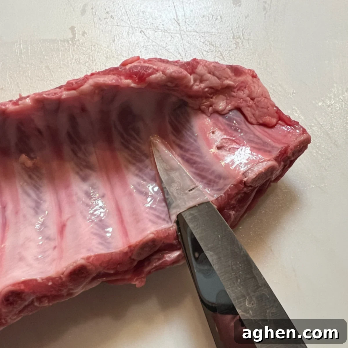 knife lifting membrane from pork ribs
