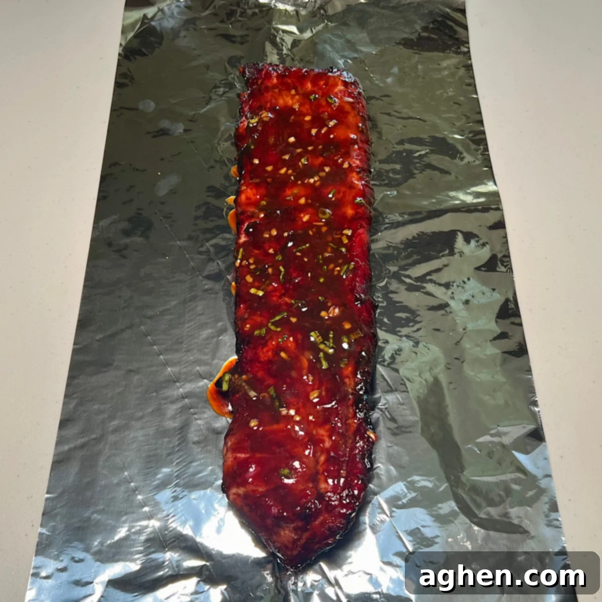 asian glazed pork ribs wrapped in aluminum foil for smoking