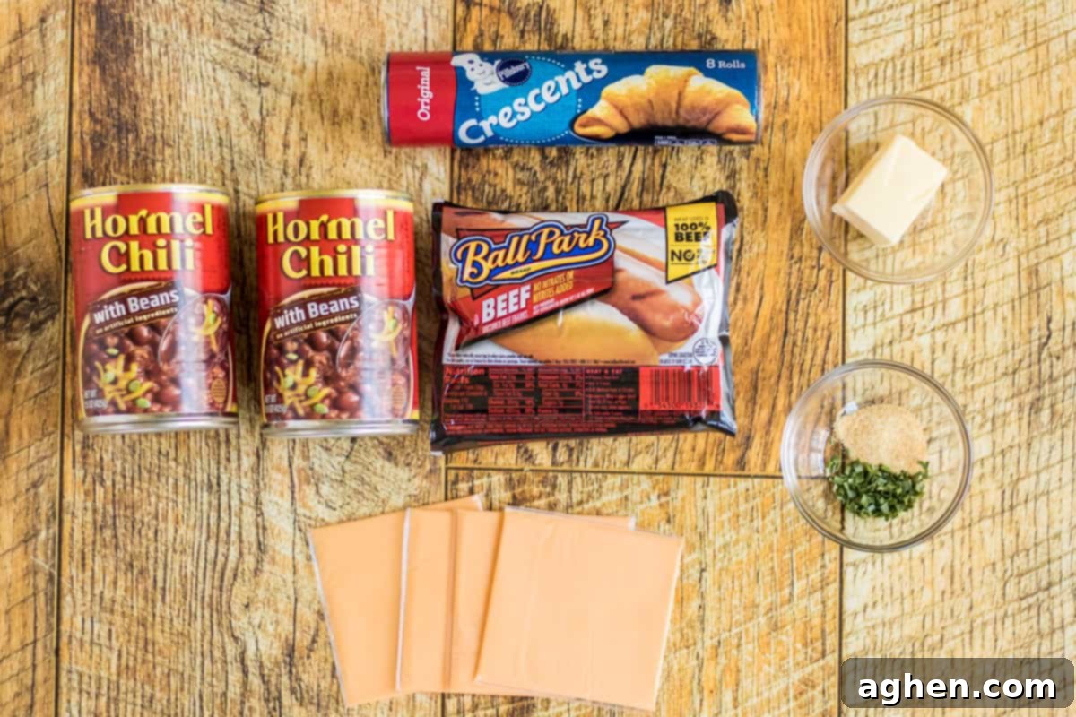 2 cans of Hormel Chili with beans, a can of Pillsbury crescent roll dough, package of 8 beef Ball Park hot dogs, 4 slices of American cheese, butter, chopped chives and garlic powder