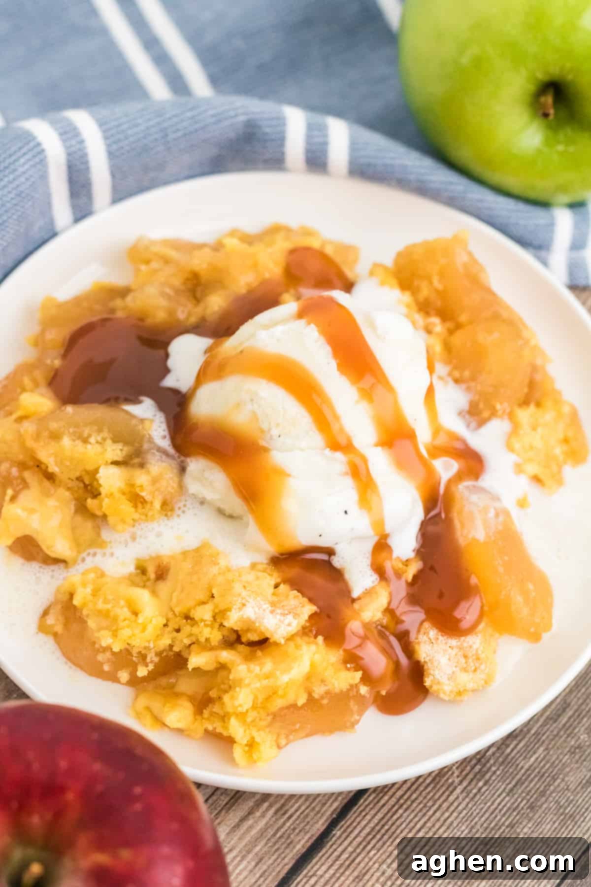 Apple dump cake with scoop of vanilla ice cream and drizzles with caramel sauce.