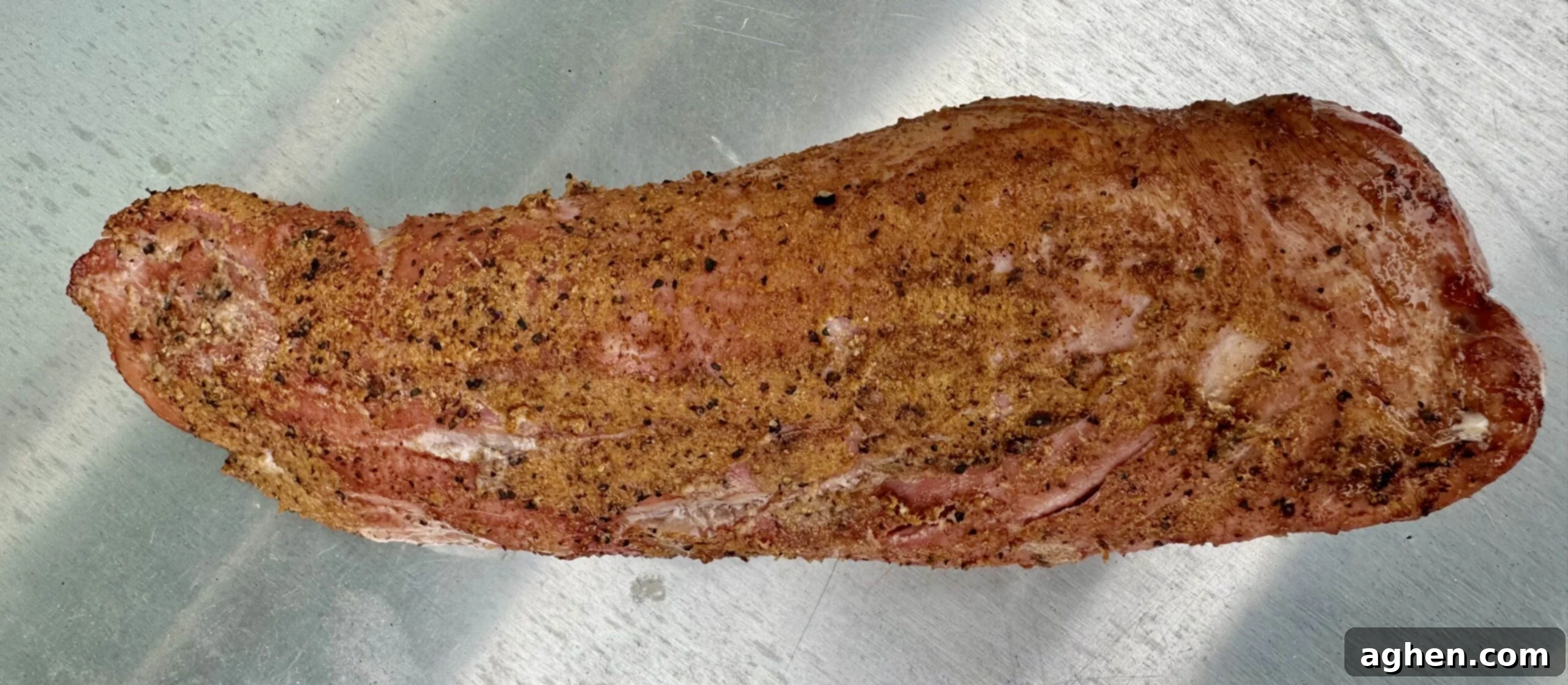 A perfectly cooked prime rib roast rotating on a Weber rotisserie spit, showing its crispy exterior and succulent texture.