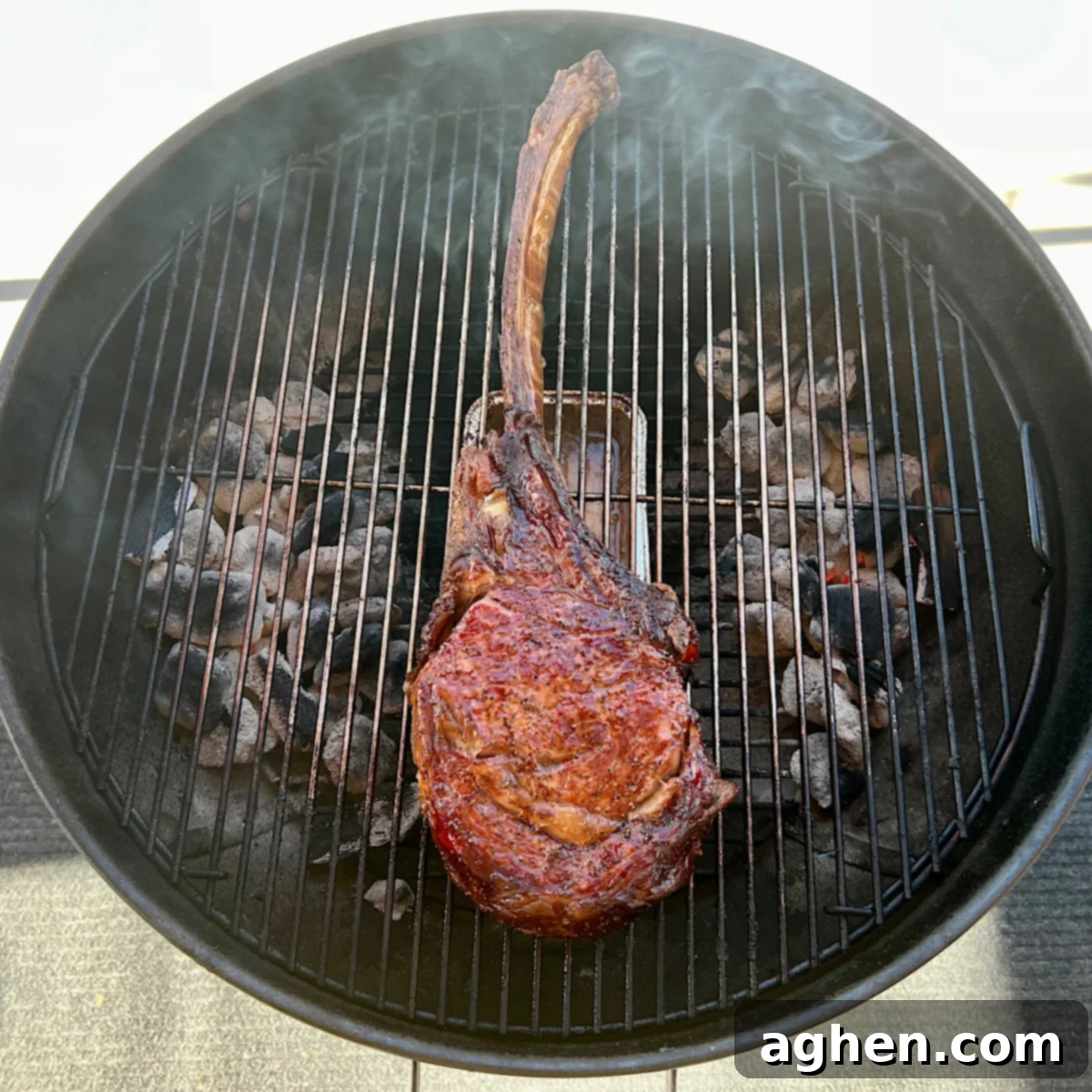 Tomahawk steak directly over hot coals on a grill grate, sizzling and searing to perfection.