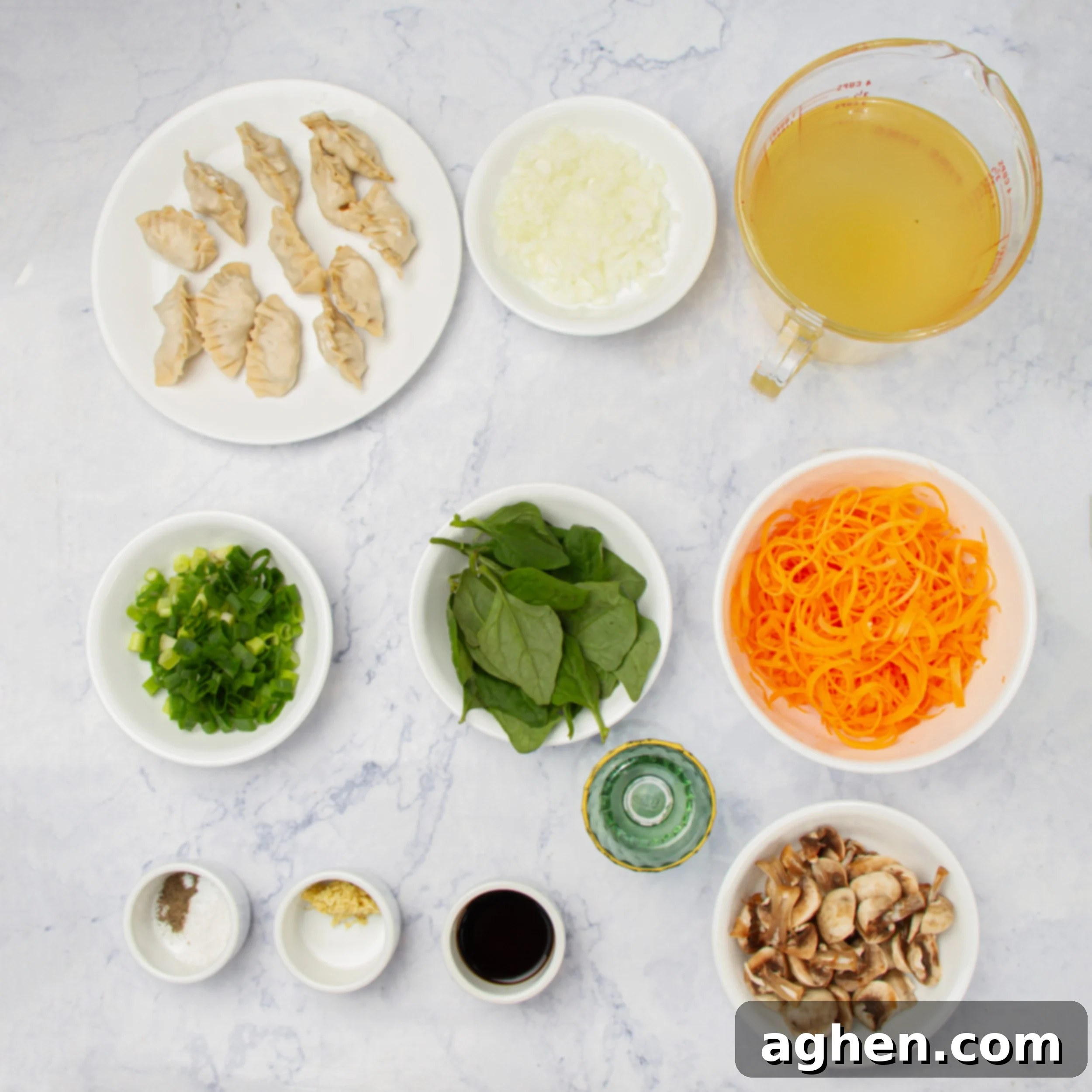 Fresh ingredients laid out for Chinese dumpling soup, including ginger, garlic, onions, spinach, and mushrooms.