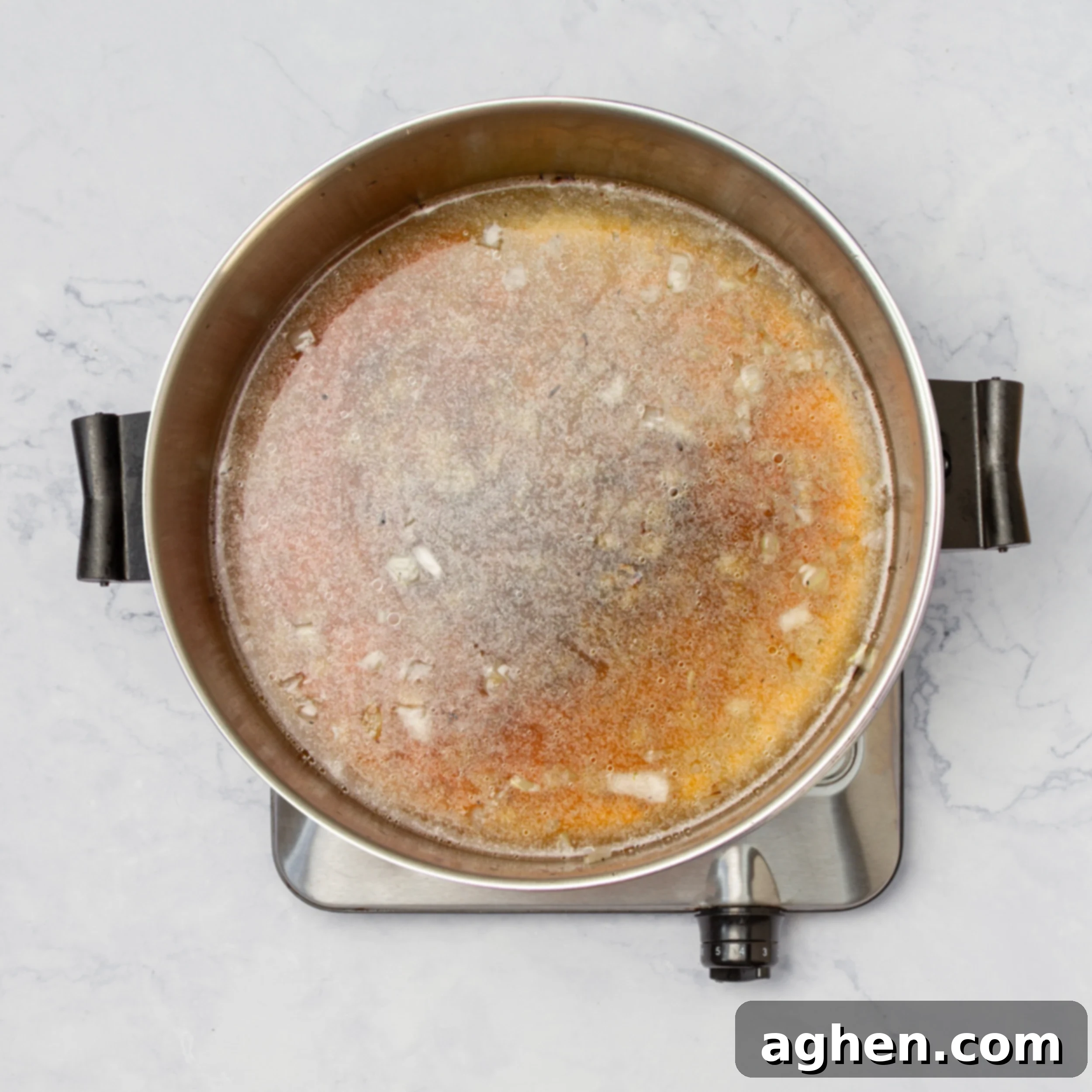 Low-sodium chicken broth and soy sauce added to the sautéed aromatics in a hot pot.