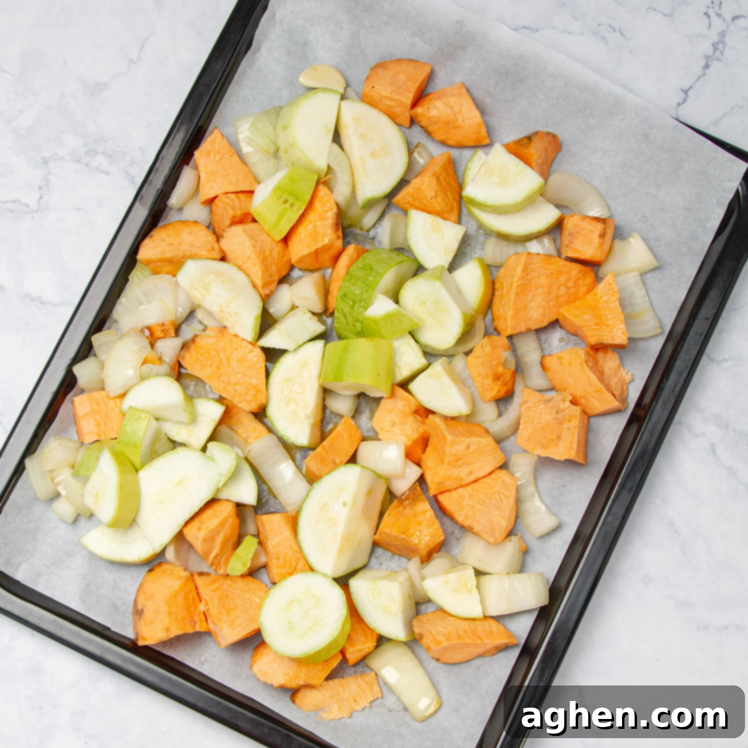 Chopped vegetables spread on a sheet pan for roasted. 