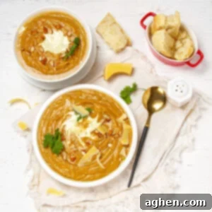 Beautiful and creamy Sweet Potato Soup in two bowls with bread on the side.