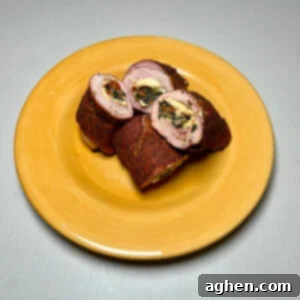 A stunning cross-section of smoked stuffed pork tenderloin, showing the layers of filling and juicy meat, ready for serving.