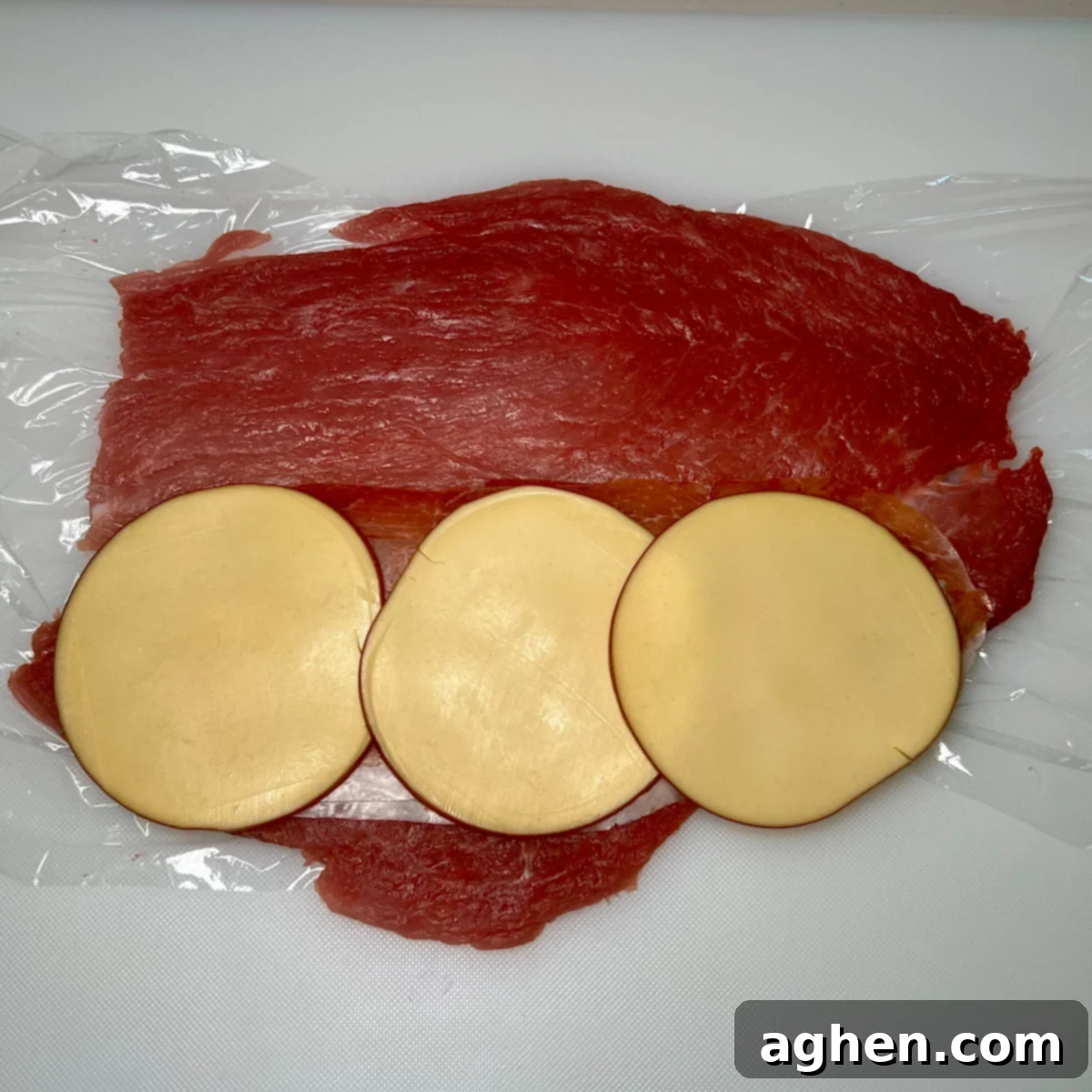 Pounded pork tenderloin laid flat, topped with prosciutto and smoked Gouda cheese, ready for the stuffing mixture.