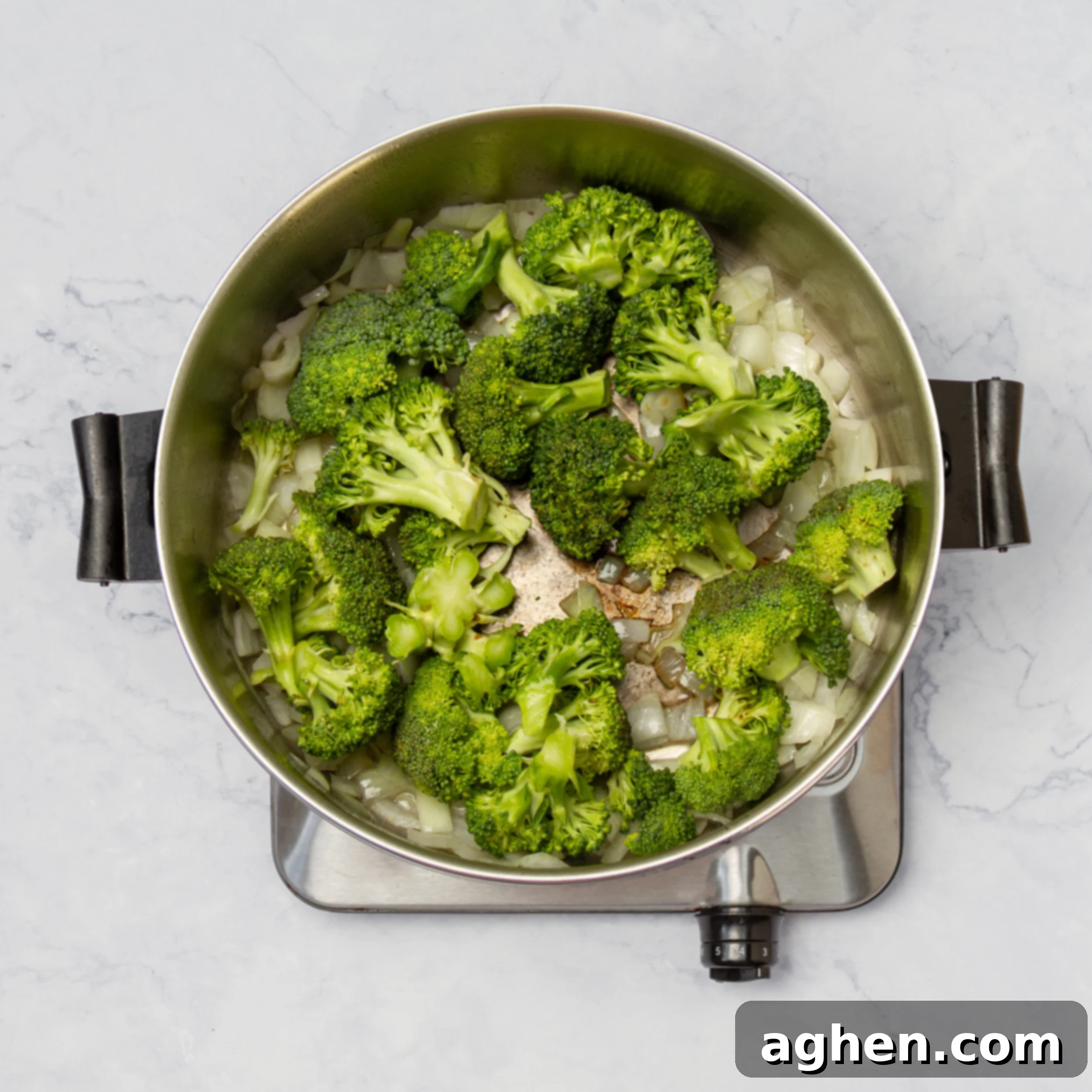 Onions and broccoli sauteing in a hot pot. 
