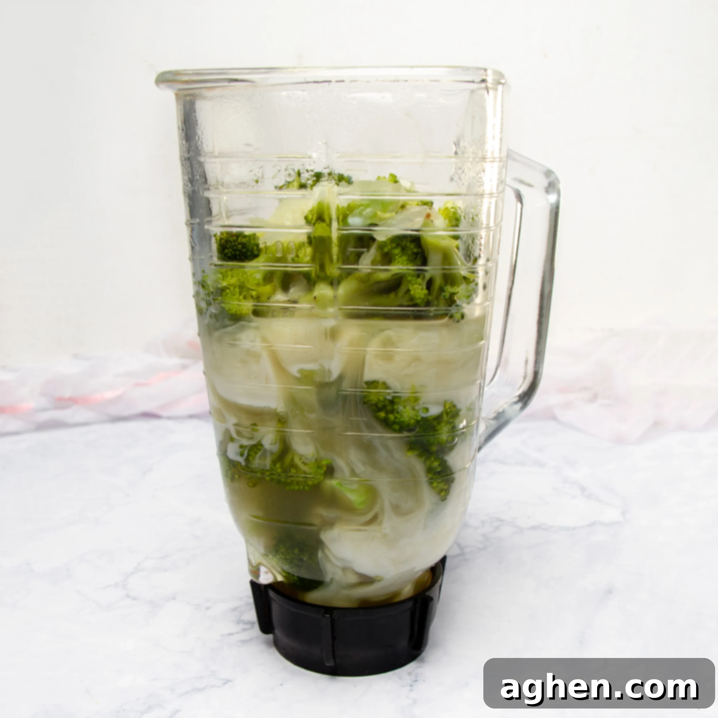 Cooked vegetables and broth in a blender with milk and slurry added.