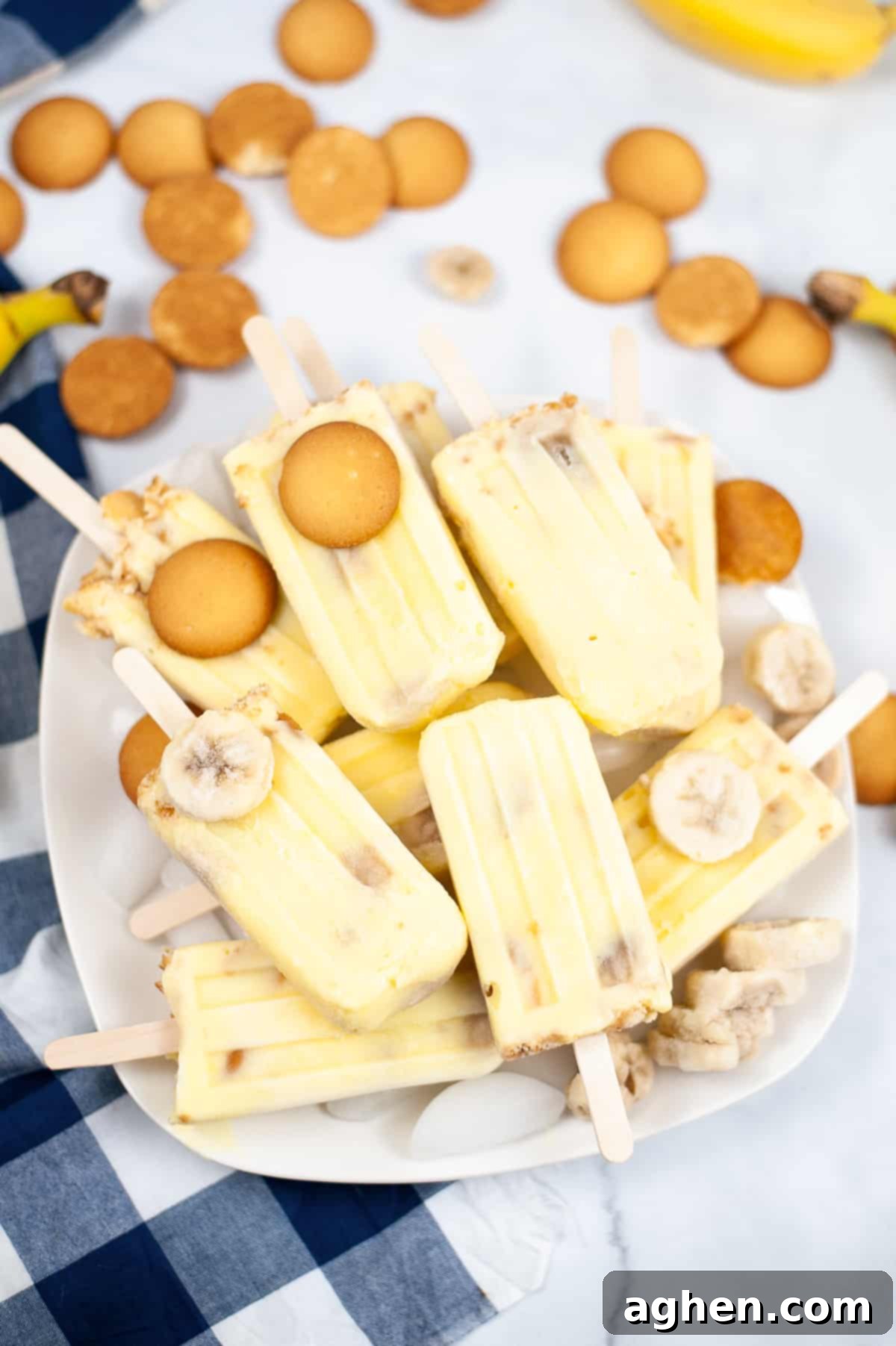 Banana popsicles piled on a platter with nilla wafers and frozen banana slices