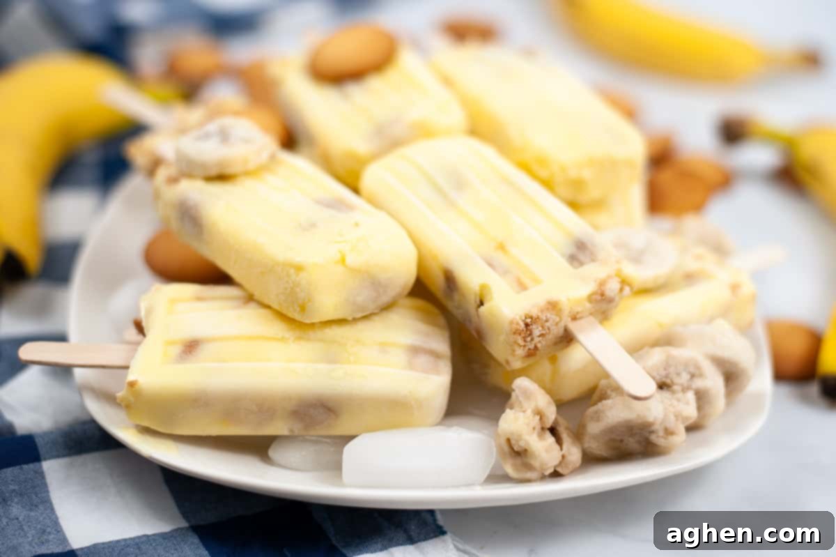 Banana pudding popsicles on a plate with vanilla wafers and frozen banana slices