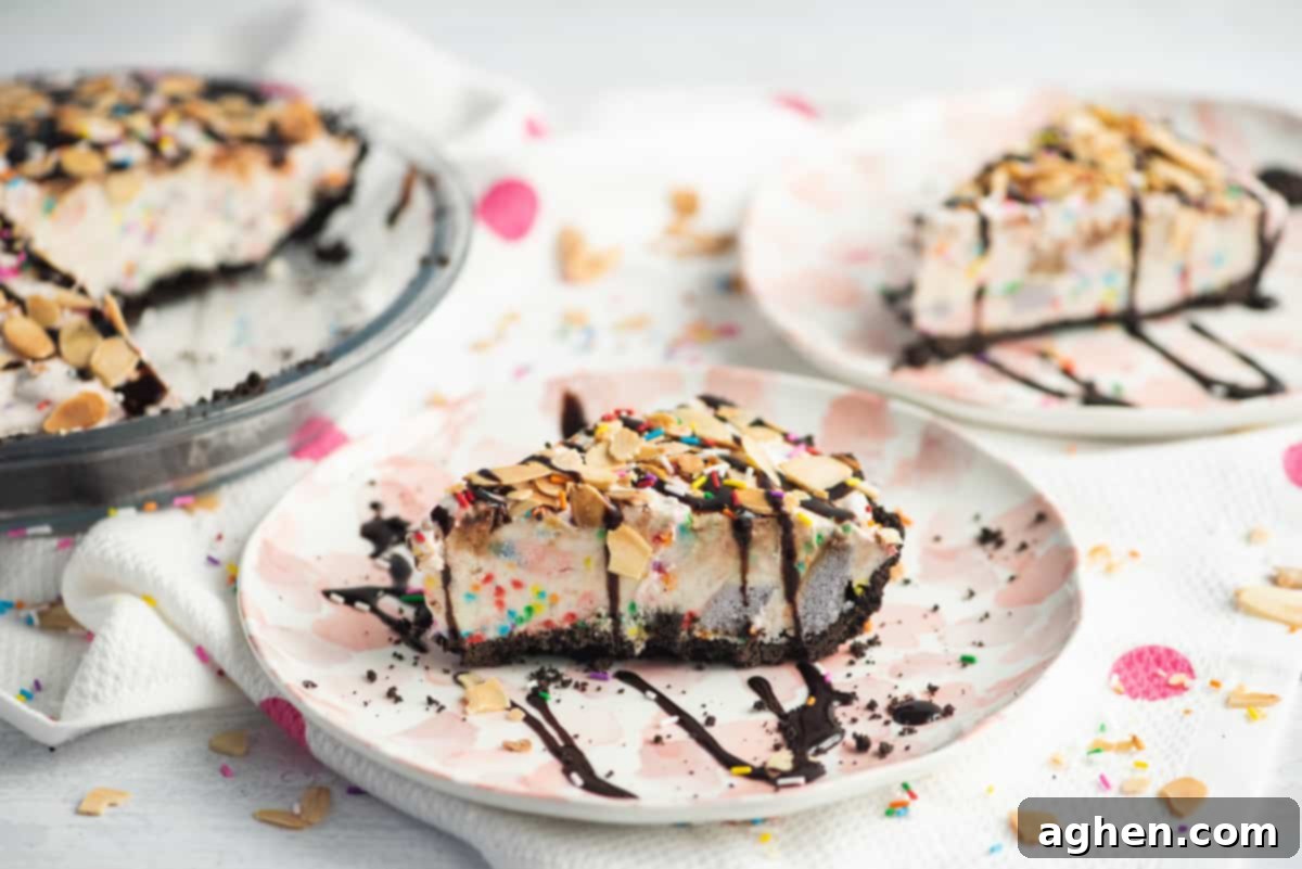 Frozen Dream Pie 11 A slice o ice cream pie with chocolate crust and rainbow sprinkles. Pie is topped with drizzle of chocolate syrup and sliced almonds. Another slice and the remainder of the pie can be seen in the background.