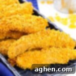 Baked Cornflake Chicken Tenders on a black plate, ready for serving.