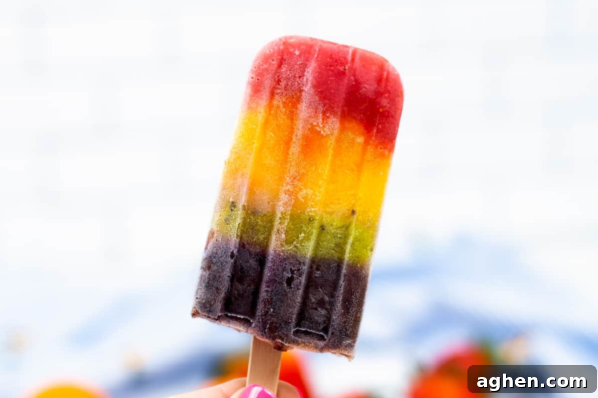 Close-up of a single vibrant red, orange, yellow, green, and purple fruit ice pop