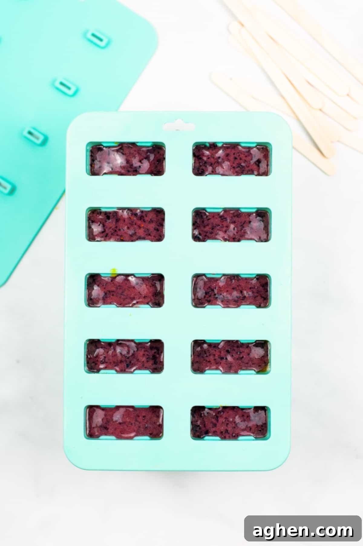 Blue popsicle mold filled with purple ice pops