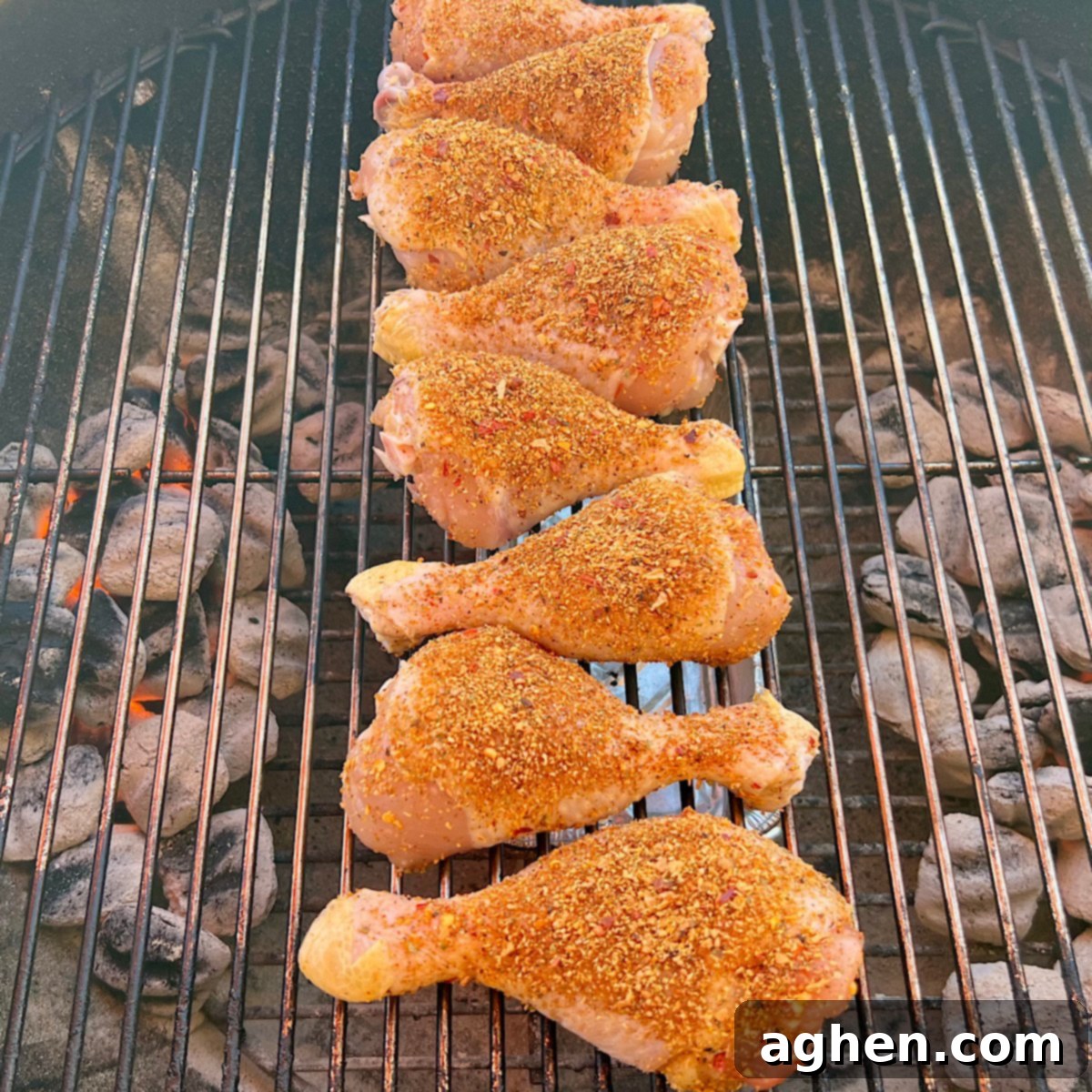 Ultimate Smoked Chicken Legs 8 up close view of raw chicken drumsticks on grill grate, showing seasoning