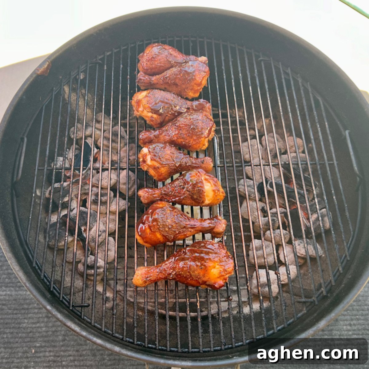 Ultimate Smoked Chicken Legs 9 smoked chicken drumsticks on grill grate with BBQ sauce applied