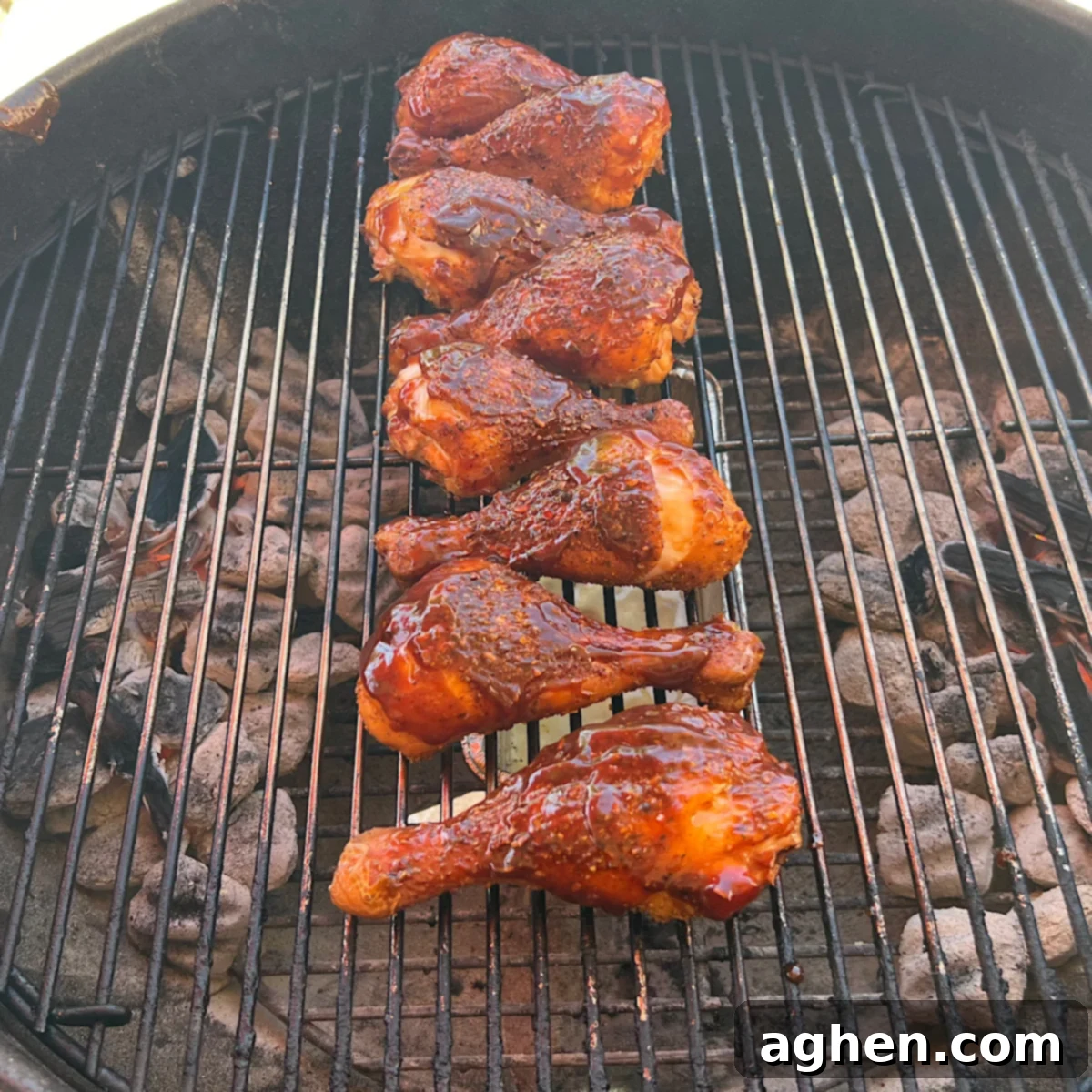 Ultimate Smoked Chicken Legs 10 up close view of smoked chicken drumsticks on grill grate, showing caramelized sauce