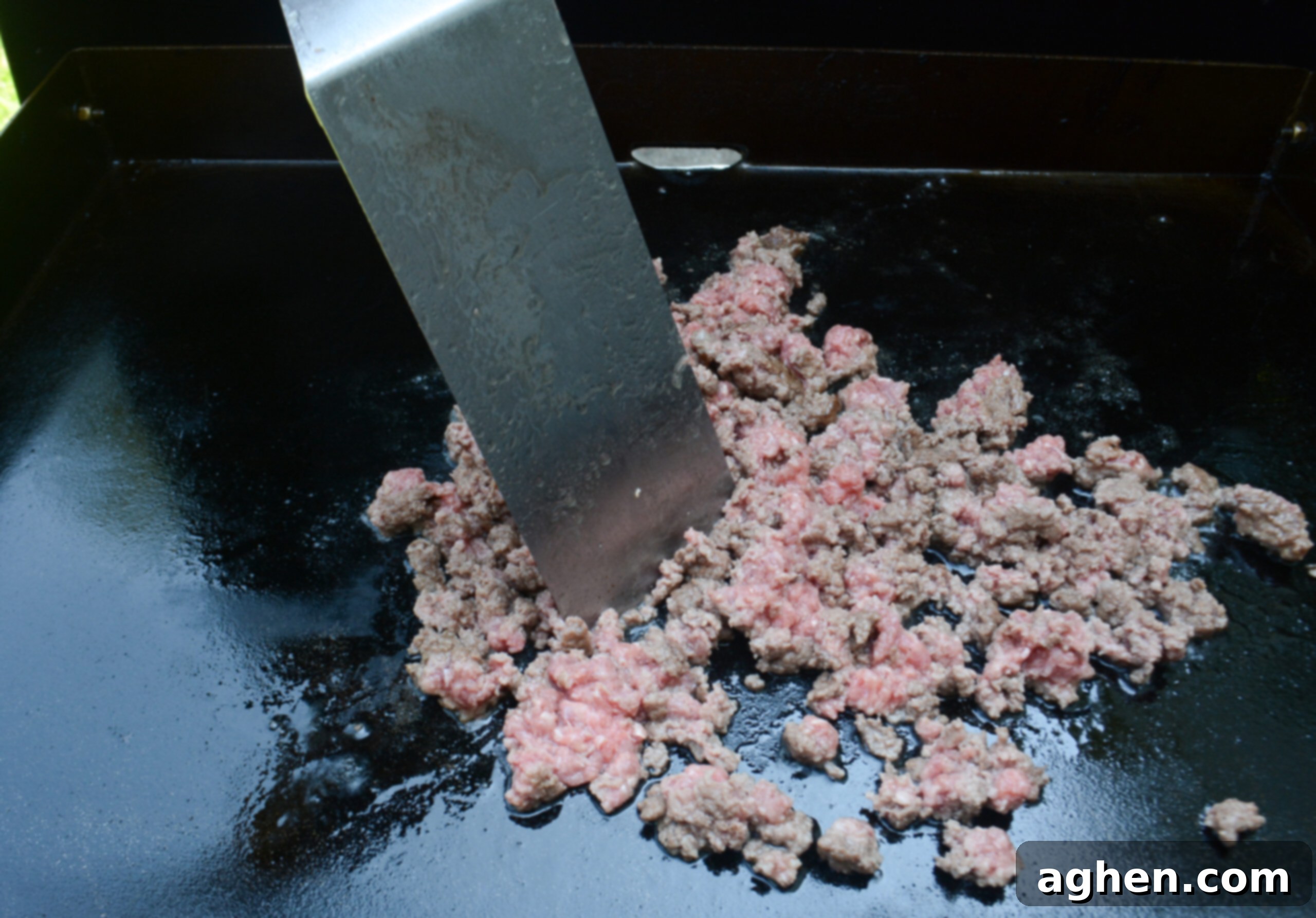 The Backyard's Best: Blackstone Tacos 4 A close up of a spatula breaking apart ground beef on the Blackstone