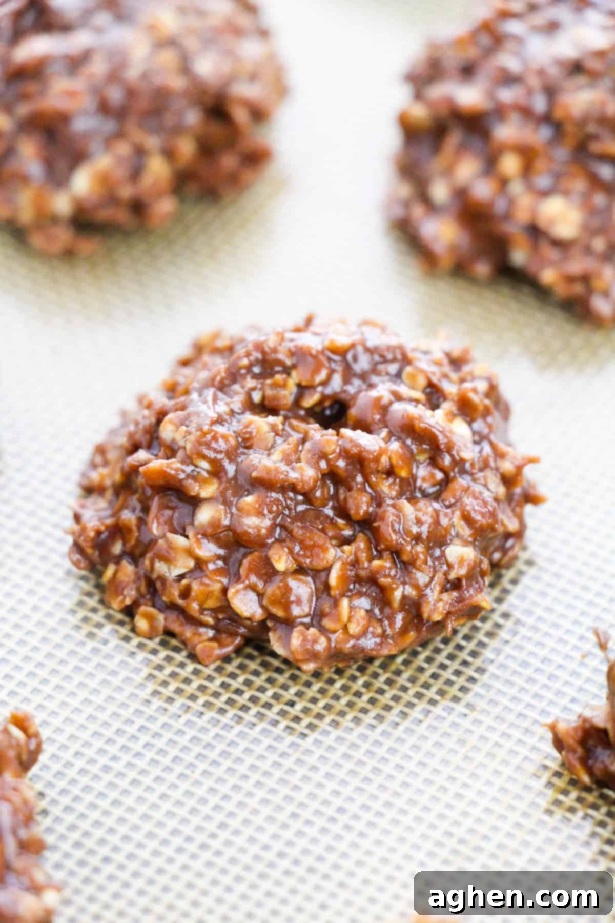Freshly made Nutella no-bake cookies, featuring visible oats, cooling perfectly on a grey silicone baking mat, ready to set and be enjoyed.
