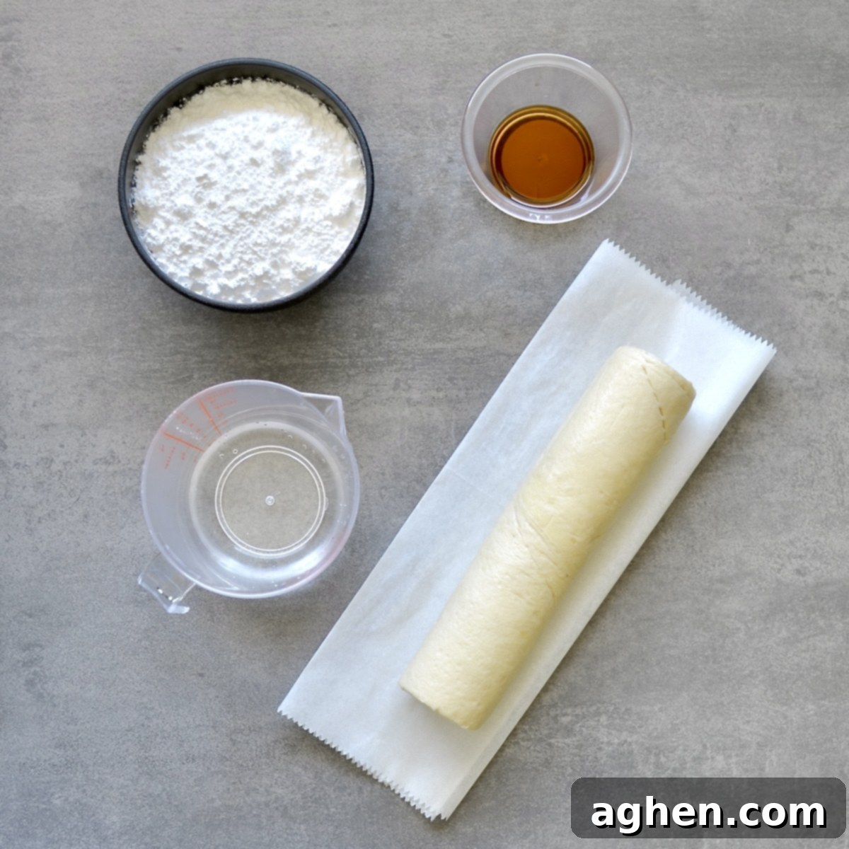 Four simple ingredients for making crescent roll donuts laid out on a wooden surface: a can of crescent rolls, powdered sugar, water, and vanilla extract.