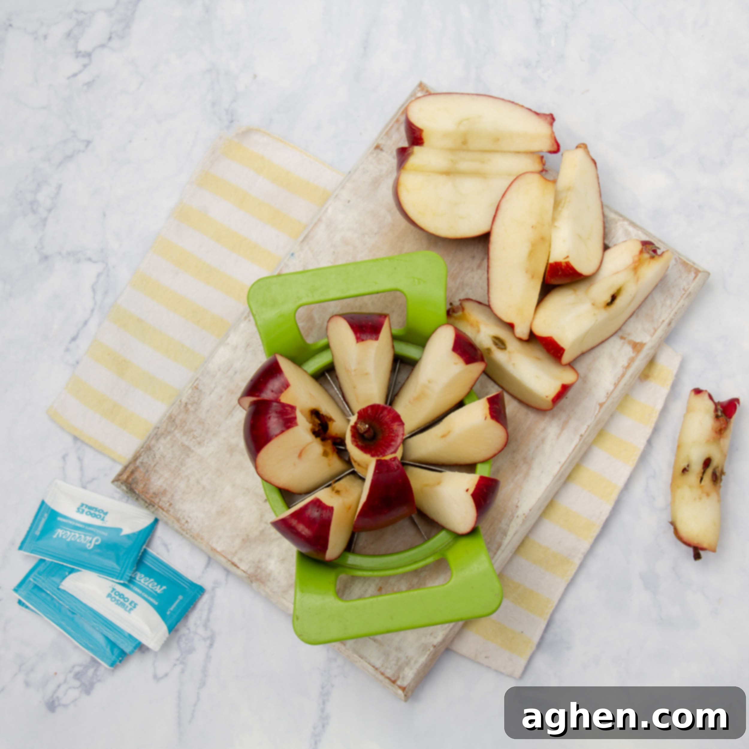 Apples being cored on a cutting board, preparing them for grating.