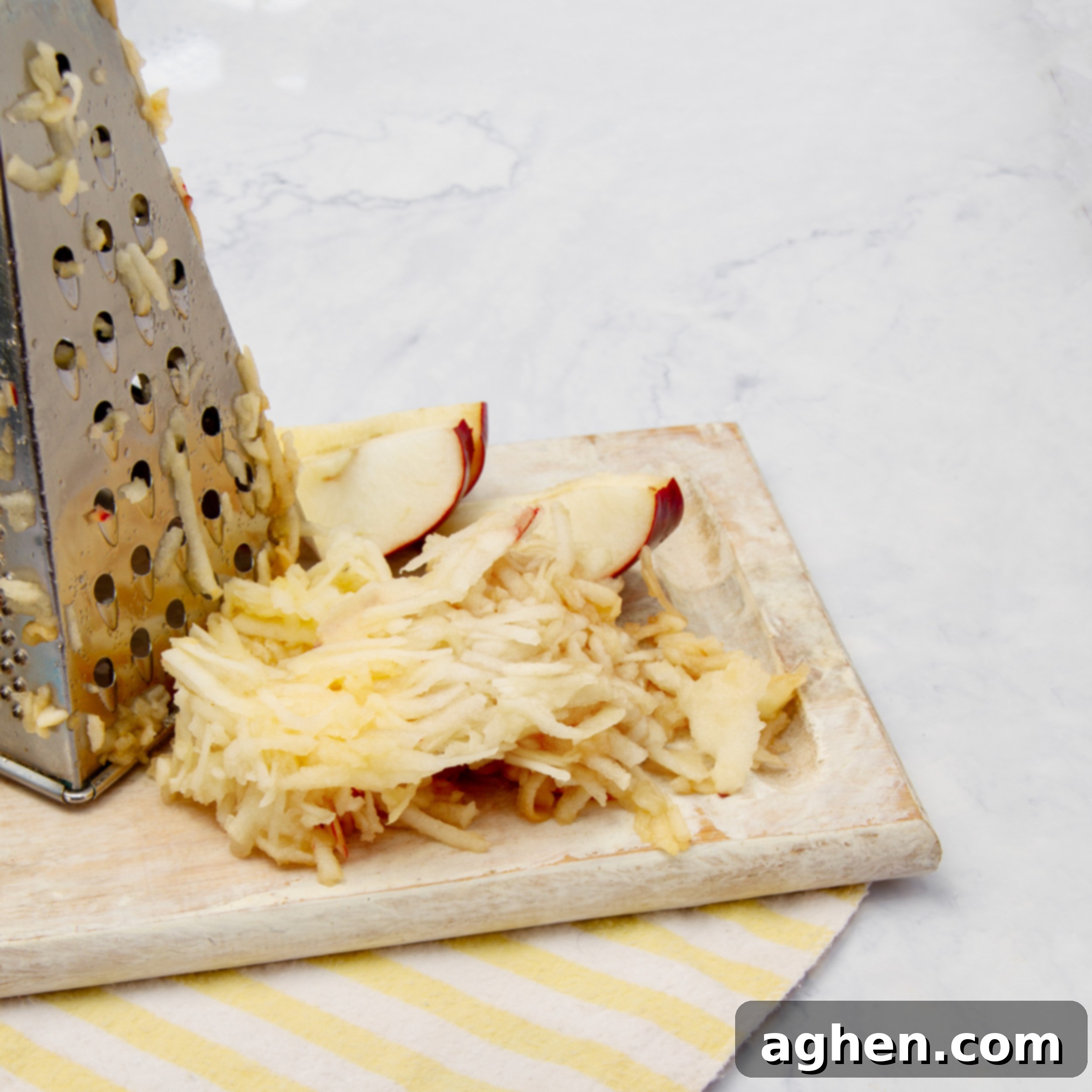 Apples being grated, showing the fine texture perfect for jam making.