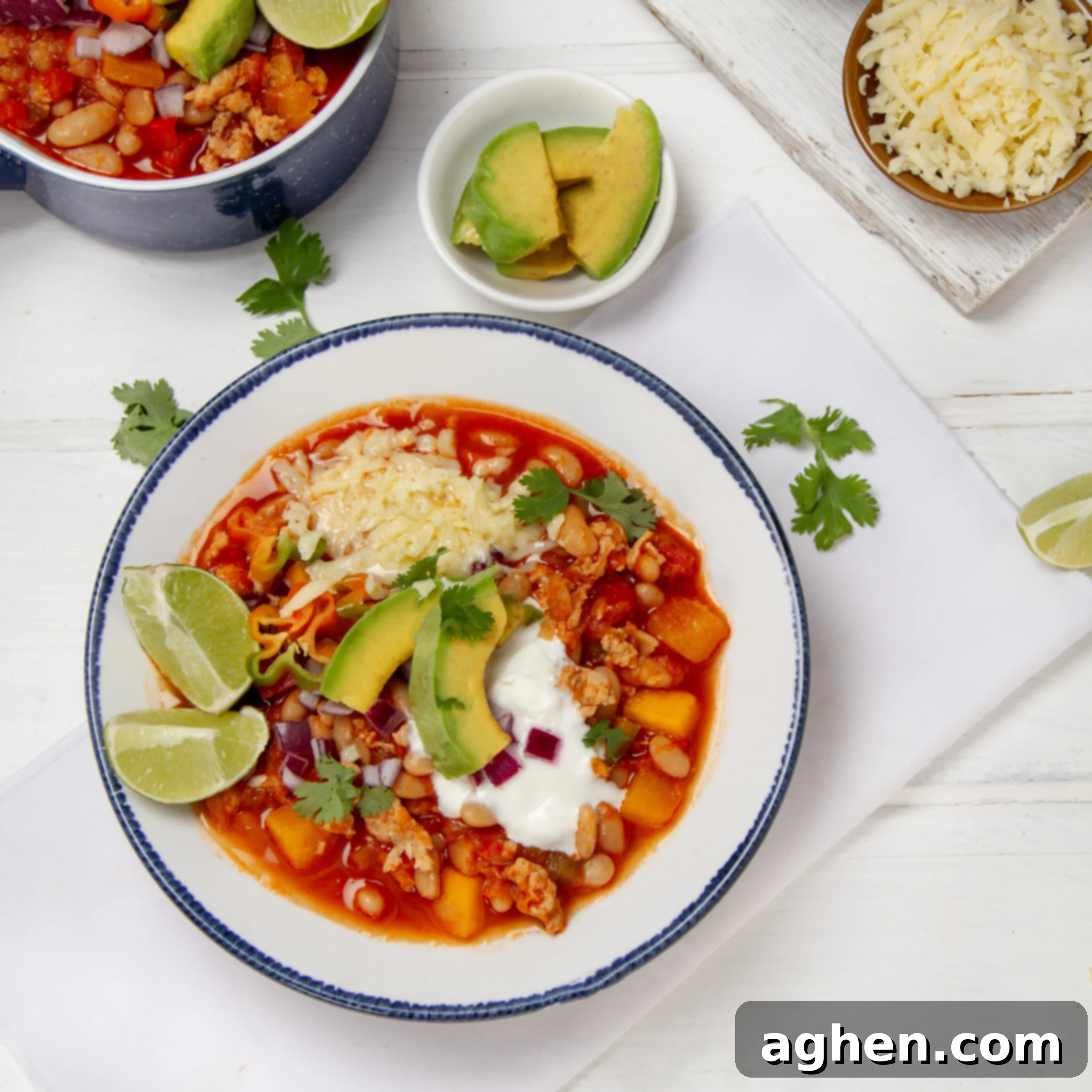 Chunky and delicious Turkey Pumpkin Chili in a bowl, topped with Greek yogurt, fresh limes, and cilantro.