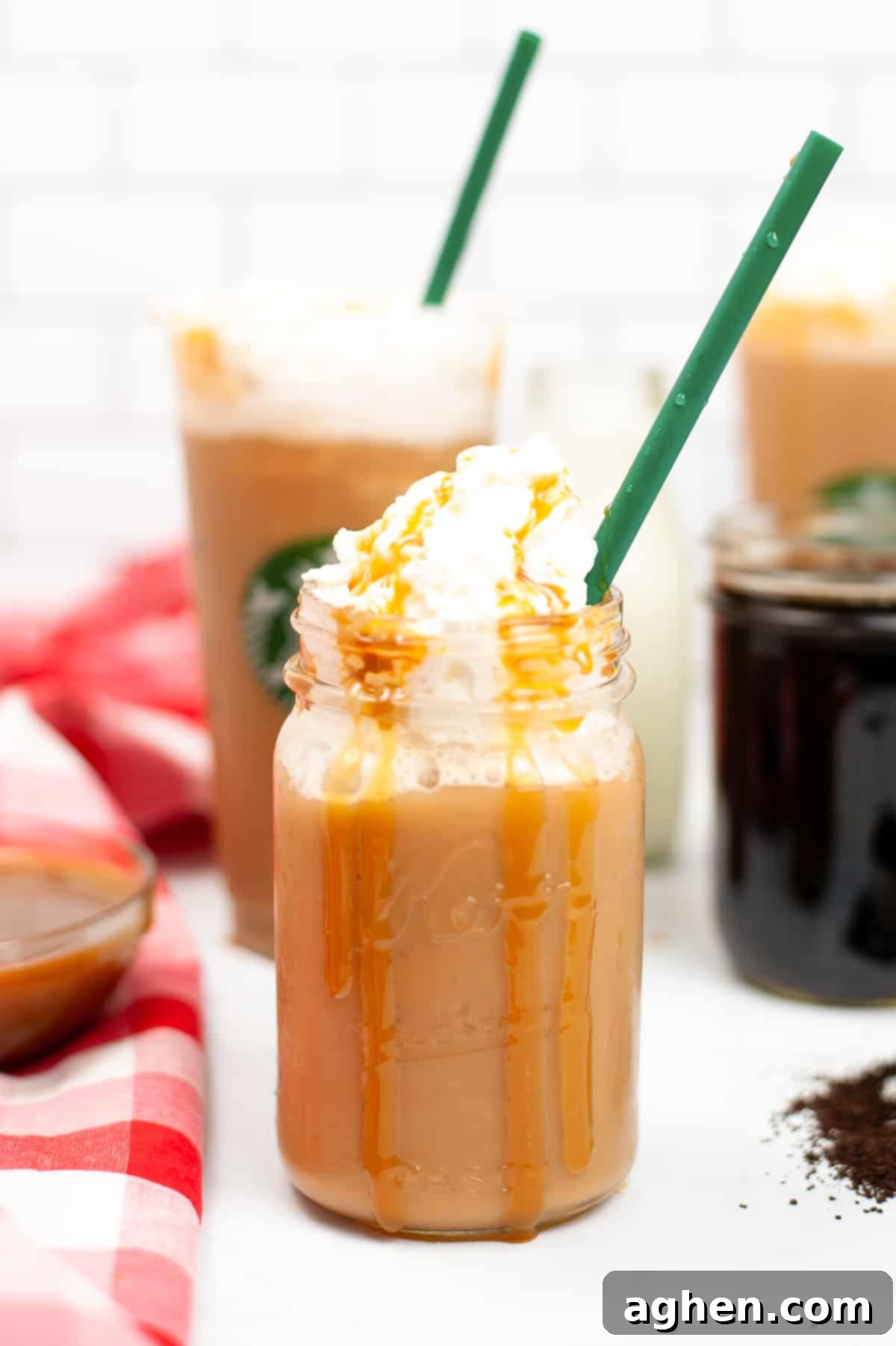 Frosted Caramel Delight 2 Caramel Frappuccino topped with whipped cream and caramel drizzle served in a mason jar with green straw