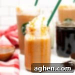 Frosted Caramel Delight 7 Caramel Frappuccino topped with whipped cream and caramel drizzle served in a mason jar with green straw